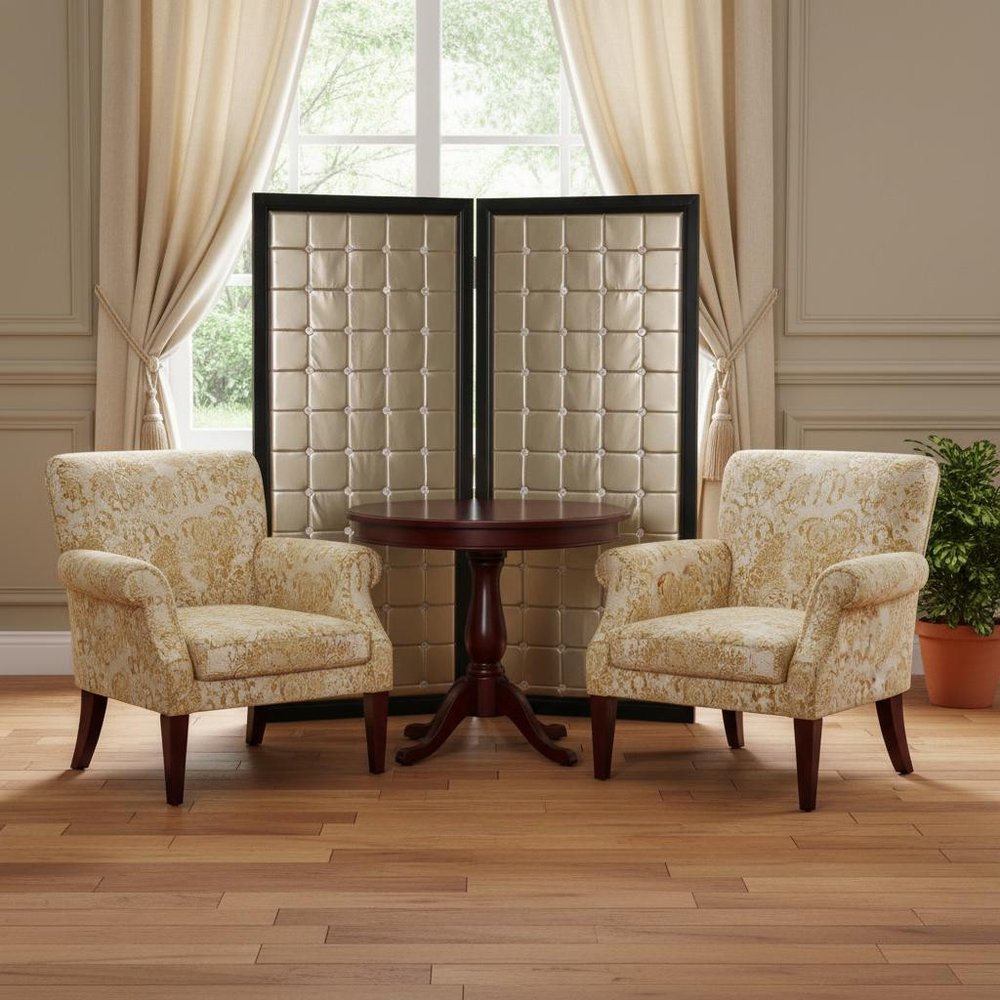 Cream floral armchairs with dark wood legs flank a round pedestal table; a gold fabric folding two-panel room divider stands in a classic living room.