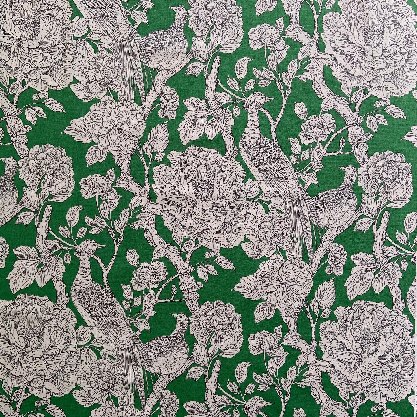 Green background fabric with white line art of birds among large peony blossoms and branches