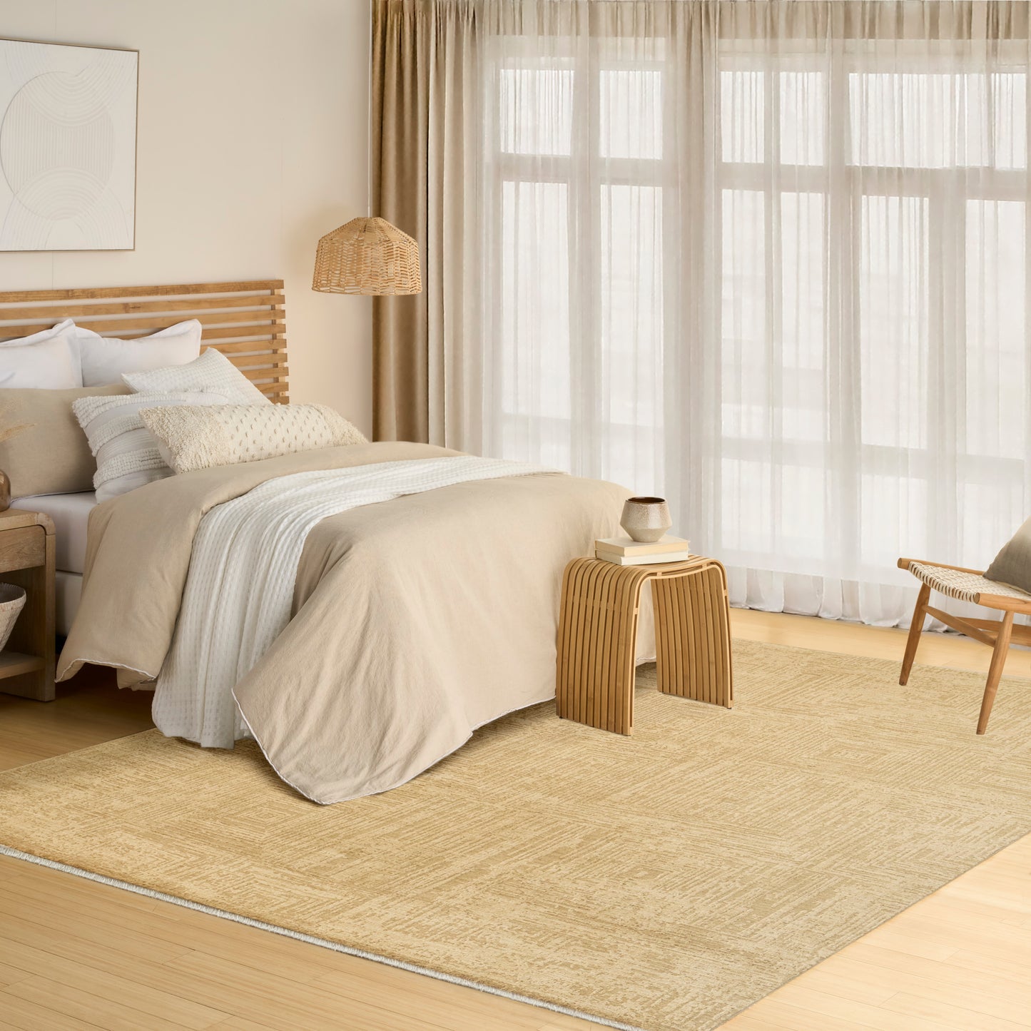 Neutral-toned bedroom with beige bedding, wooden slatted bed, woven rug, rattan lamp, slatted side table and sheer curtains.
