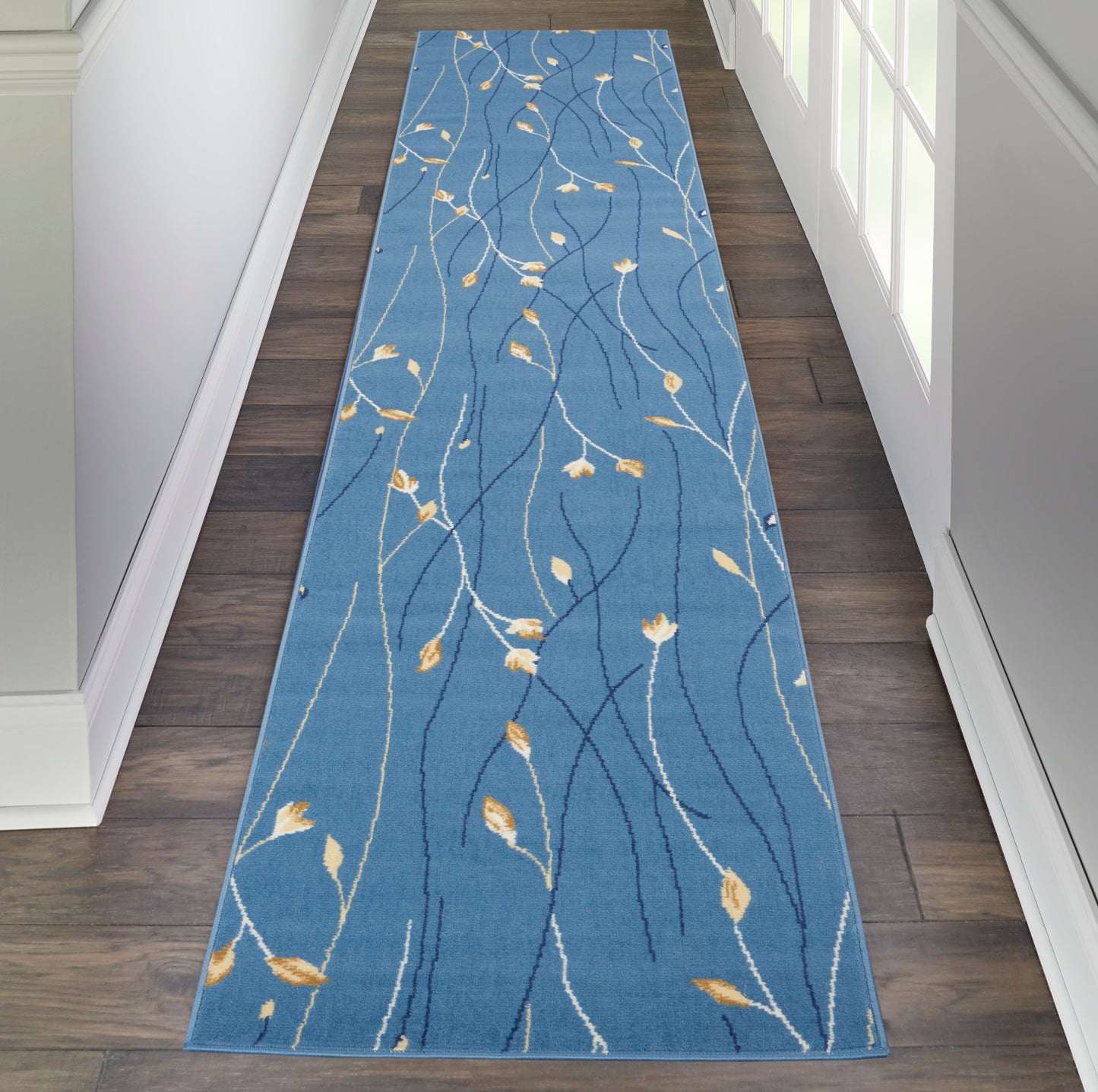 Blue hallway runner rug with white & pale yellow leaf-vine pattern; rectangular, soft texture for entryway or corridor.