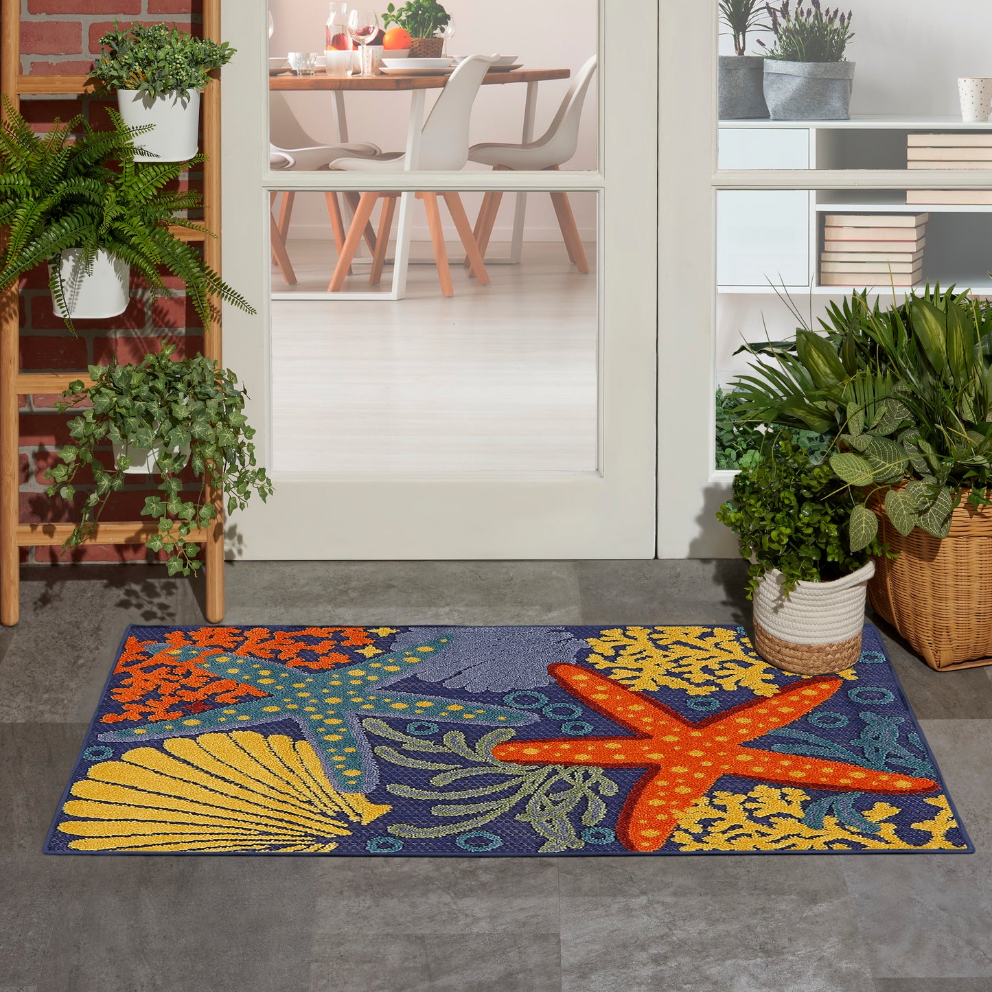 Colorful rectangular ocean-themed doormat featuring a large orange starfish, yellow seashells, and green seaweed on a blue background.