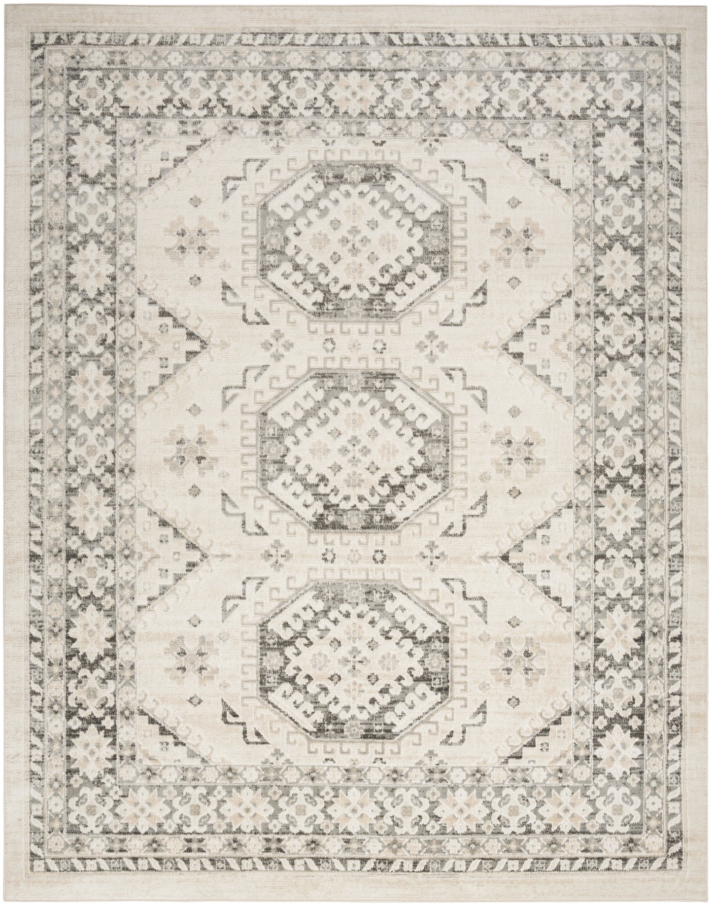 Neutral-toned area rug with three stacked hexagonal medallions, ivory and charcoal pattern, ornate floral border.