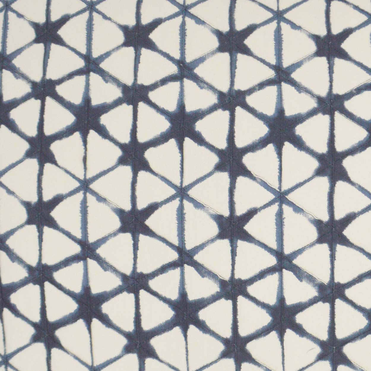 Navy blue geometric lattice on cream fabric with repeating star and triangle motifs.
