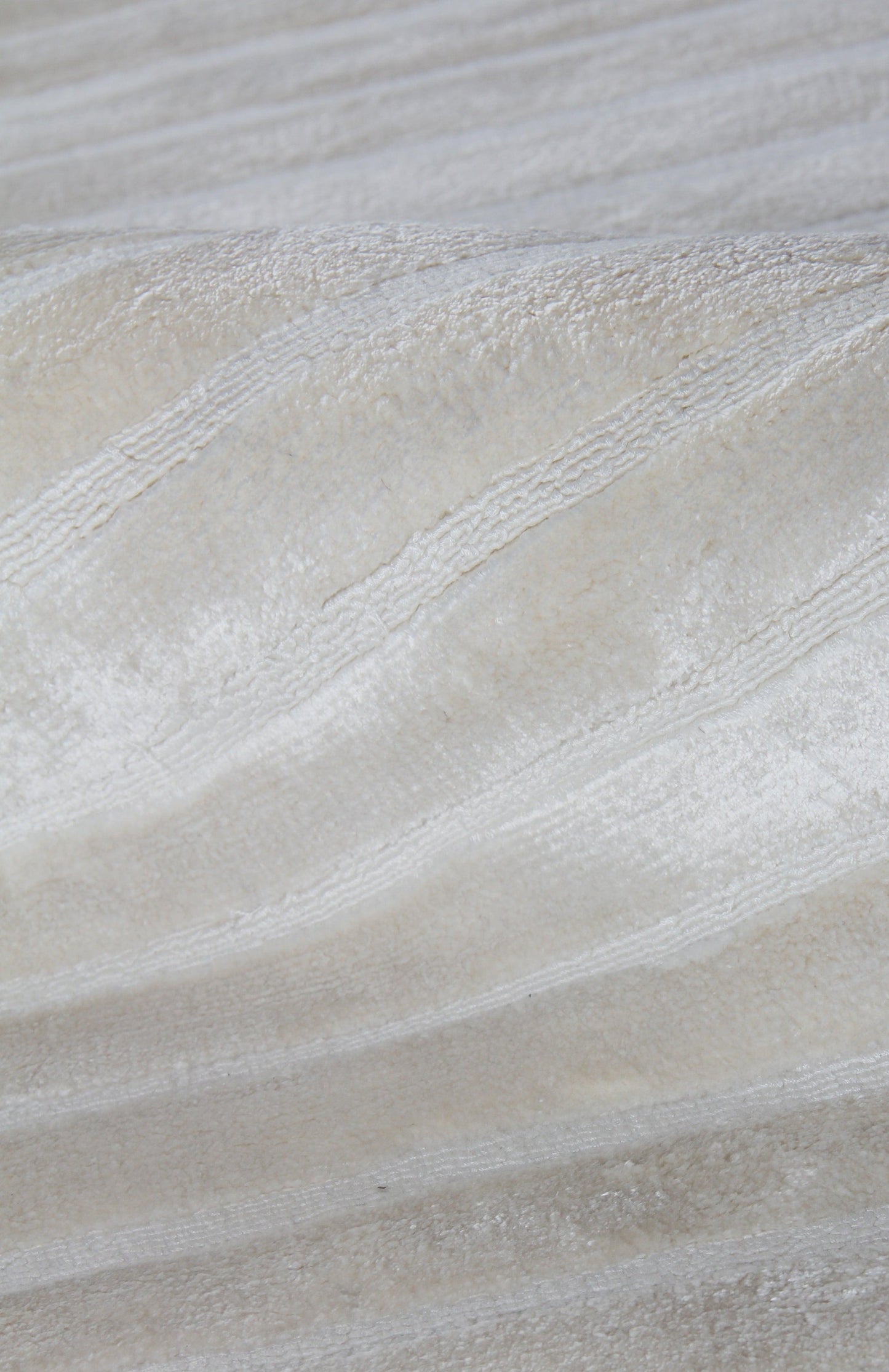 Ivory indoor rug with high-low texture and diagonal rib weave; hand-loomed, plush surface. 4' x 6'.