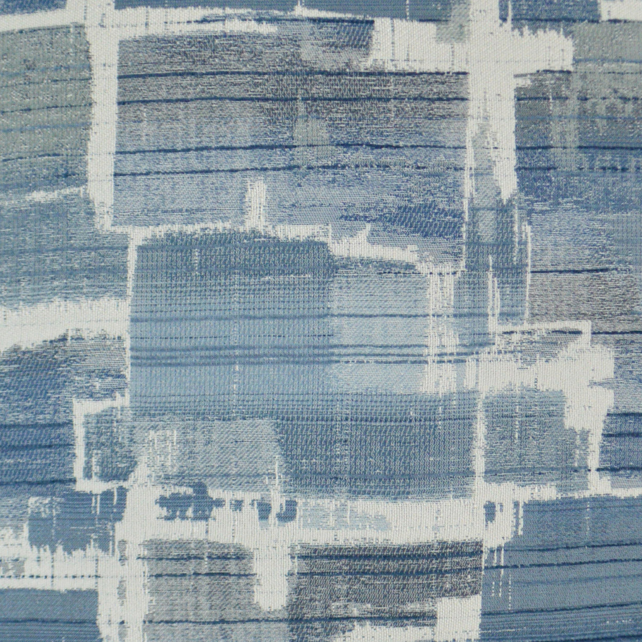 Blue abstract patchwork fabric pattern with white brushstroke outlines and varying blue shades.