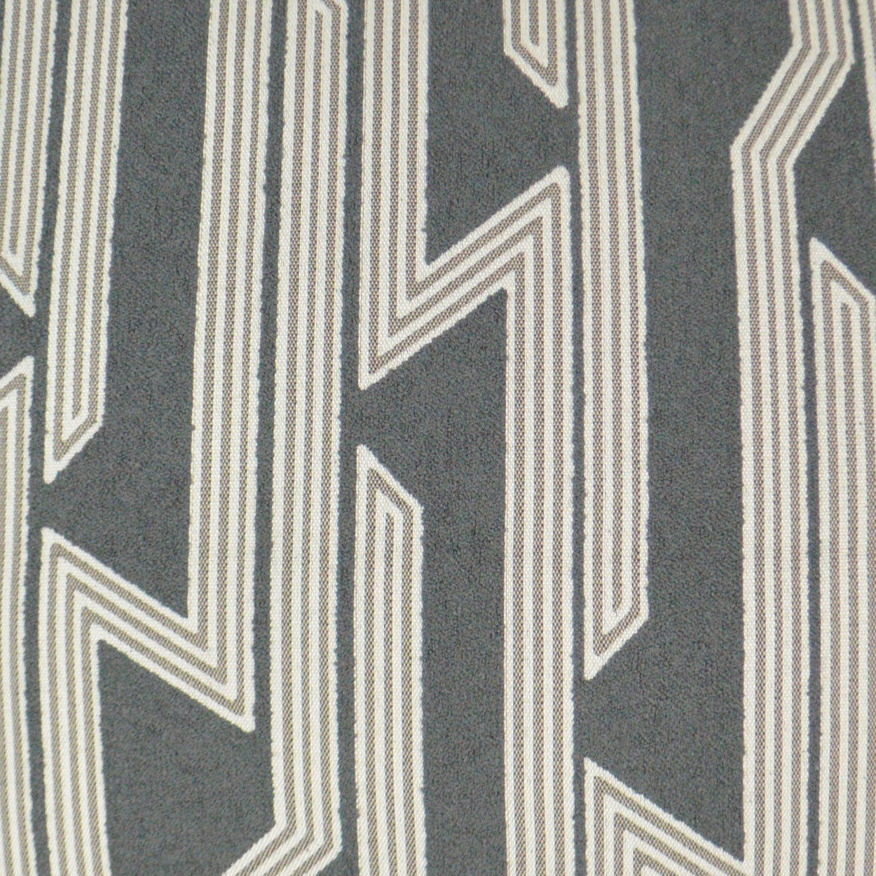 Charcoal gray fabric with white geometric zigzag stripe pattern, modern textured textile.
