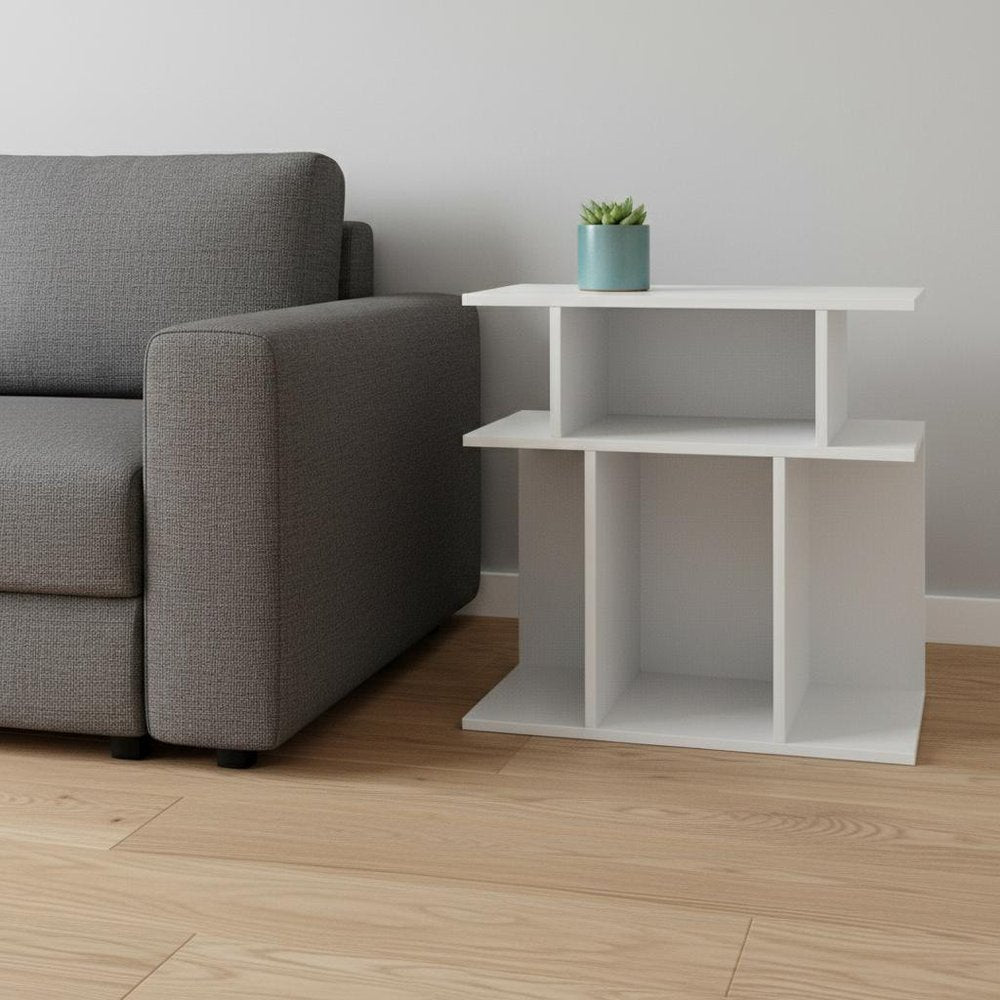 White wood end table with six open shelves beside a gray fabric sofa; small potted plant on top.