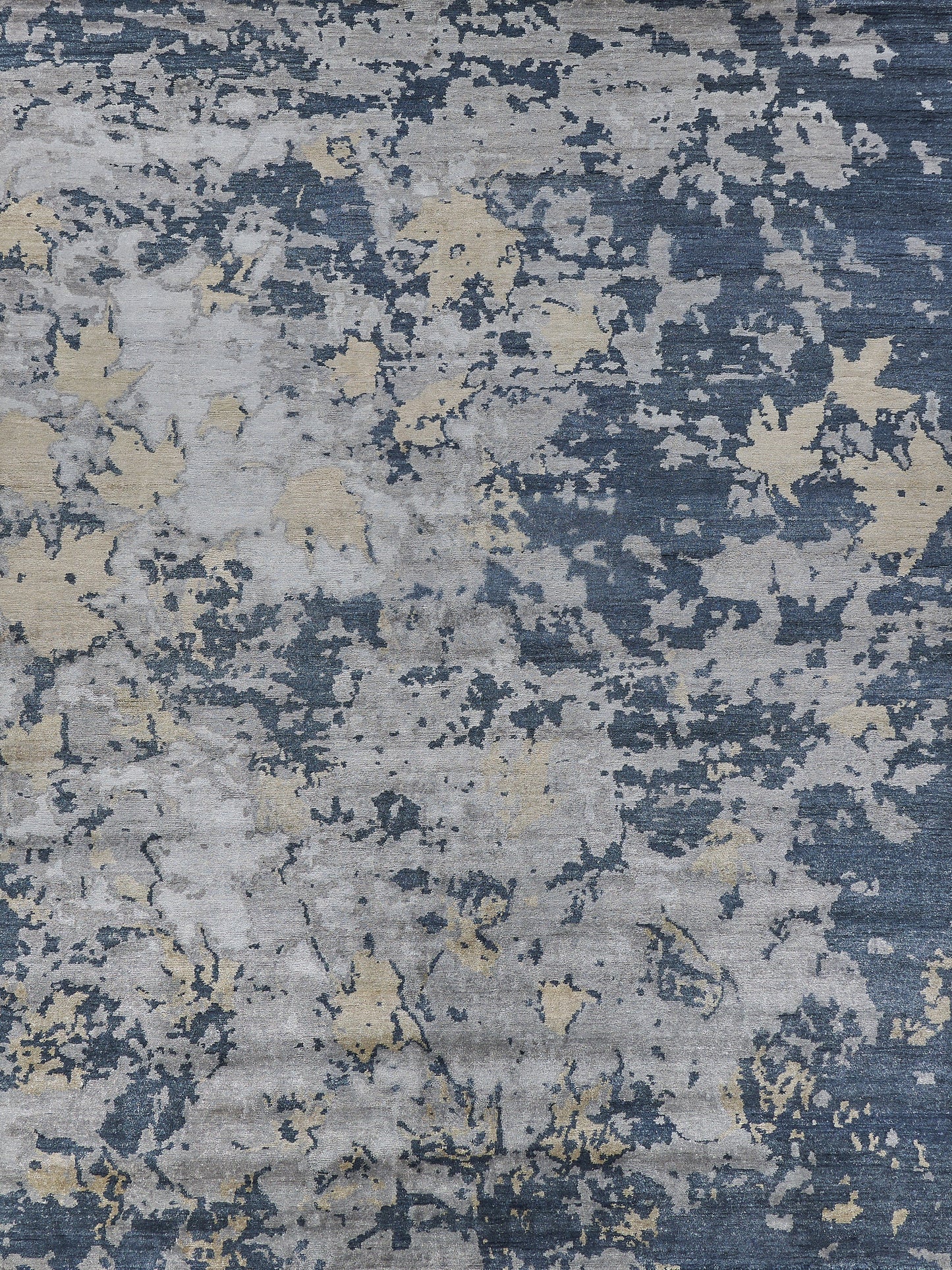 Textured area rug featuring a modern abstract design in blue, gray, and hints of gold, ideal for upscale interior decor.