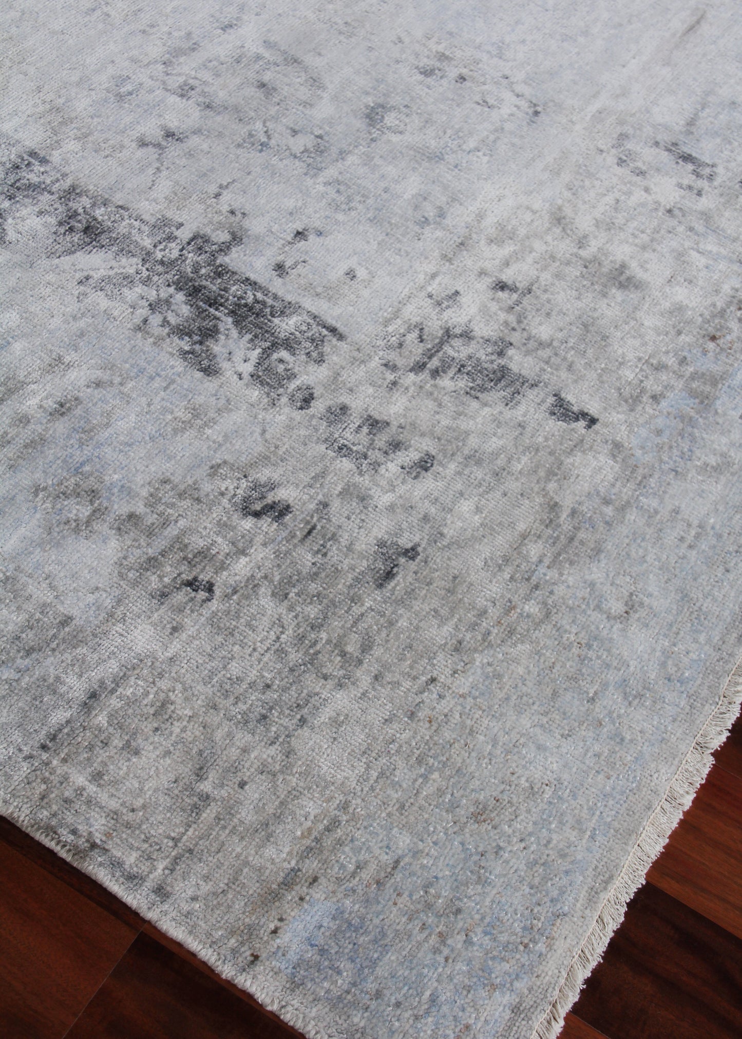 Distressed gray-blue indoor area rug with soft texture and abstract pattern for living room decor.
