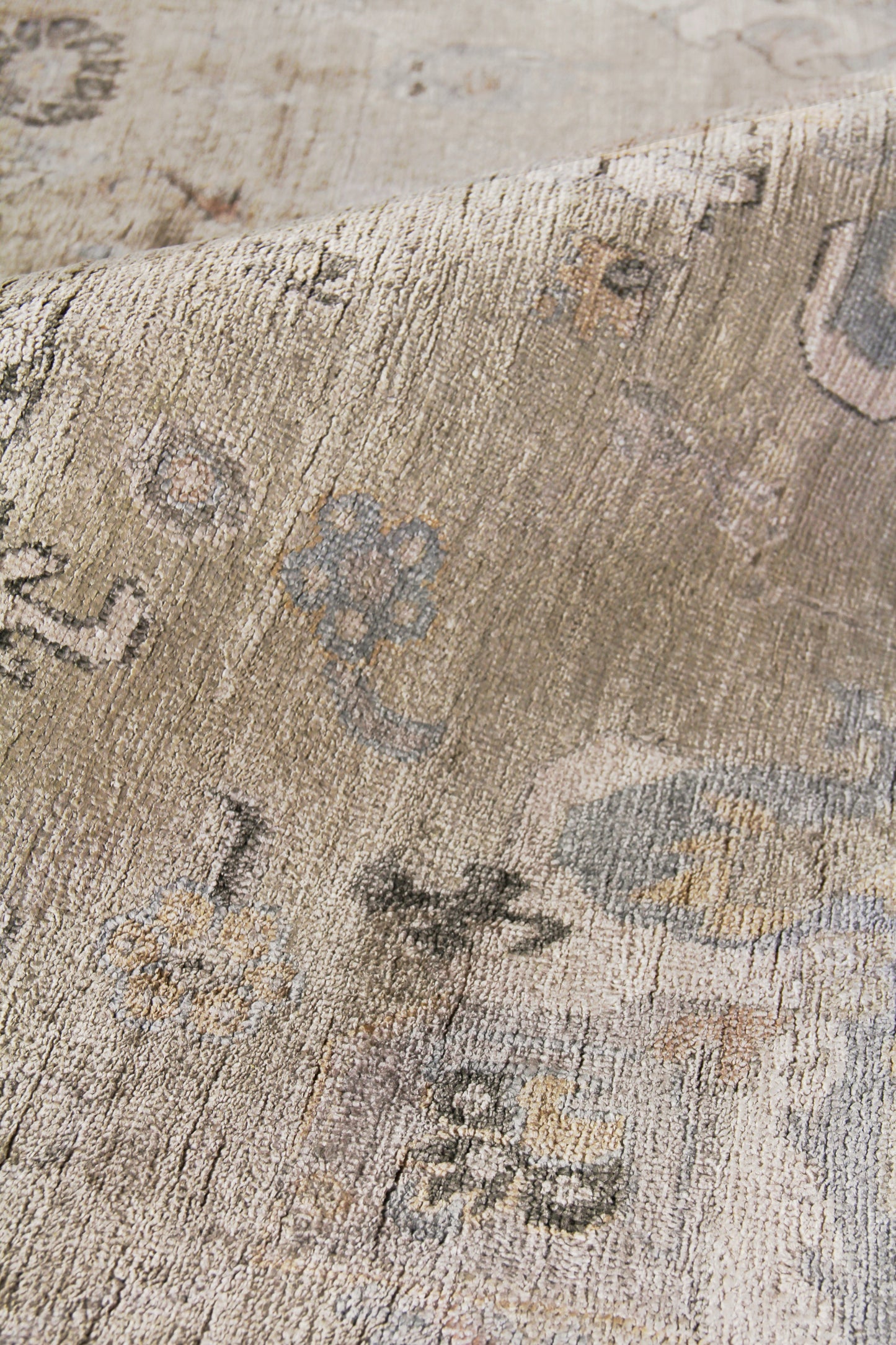 Beige vintage-style rug with faded blue-gray floral patterns and a close-up woven texture; size 6' x 9', hand-knotted.