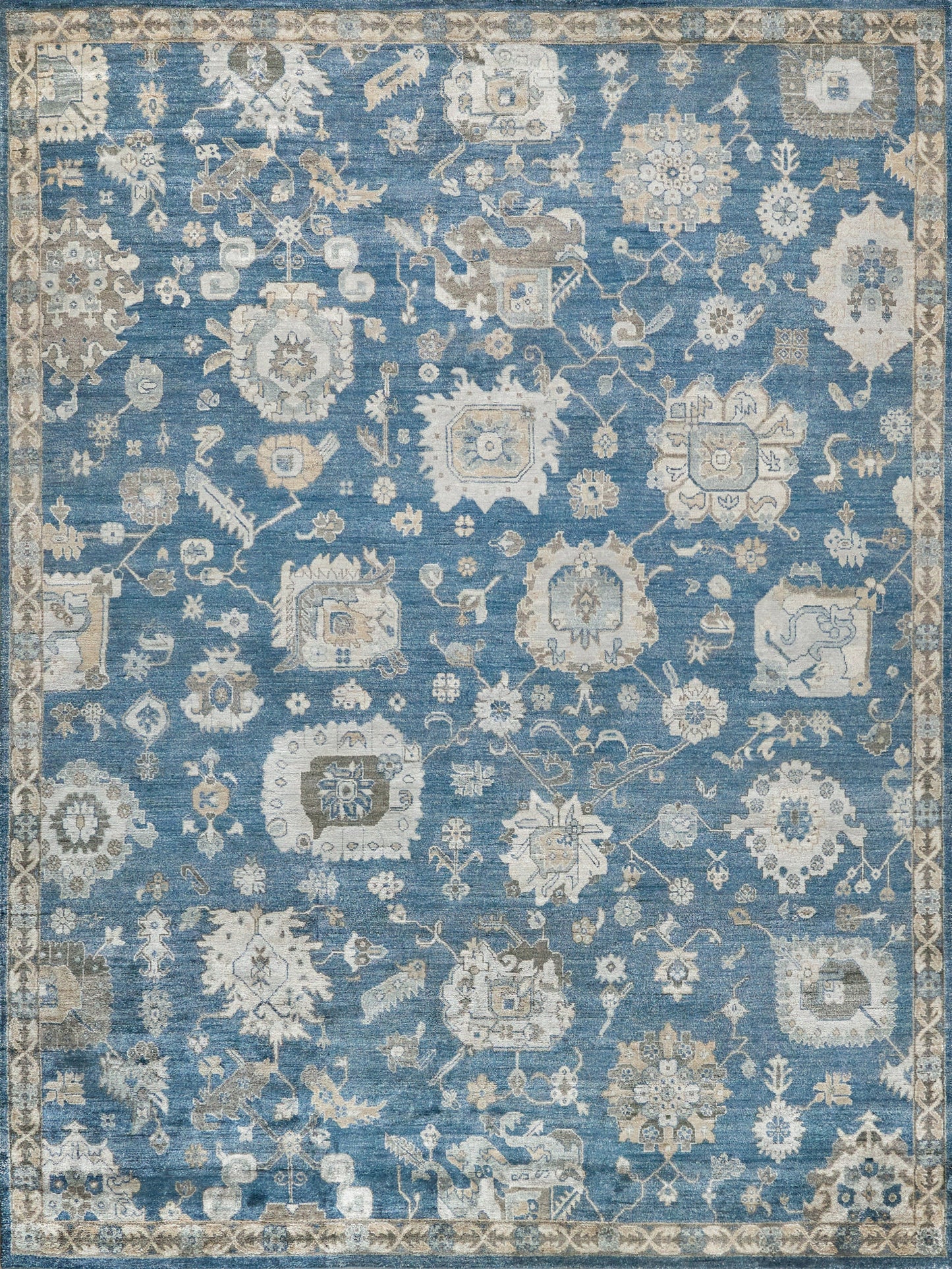 Blue distressed oriental area rug with ivory and beige floral medallions and ornate border.
