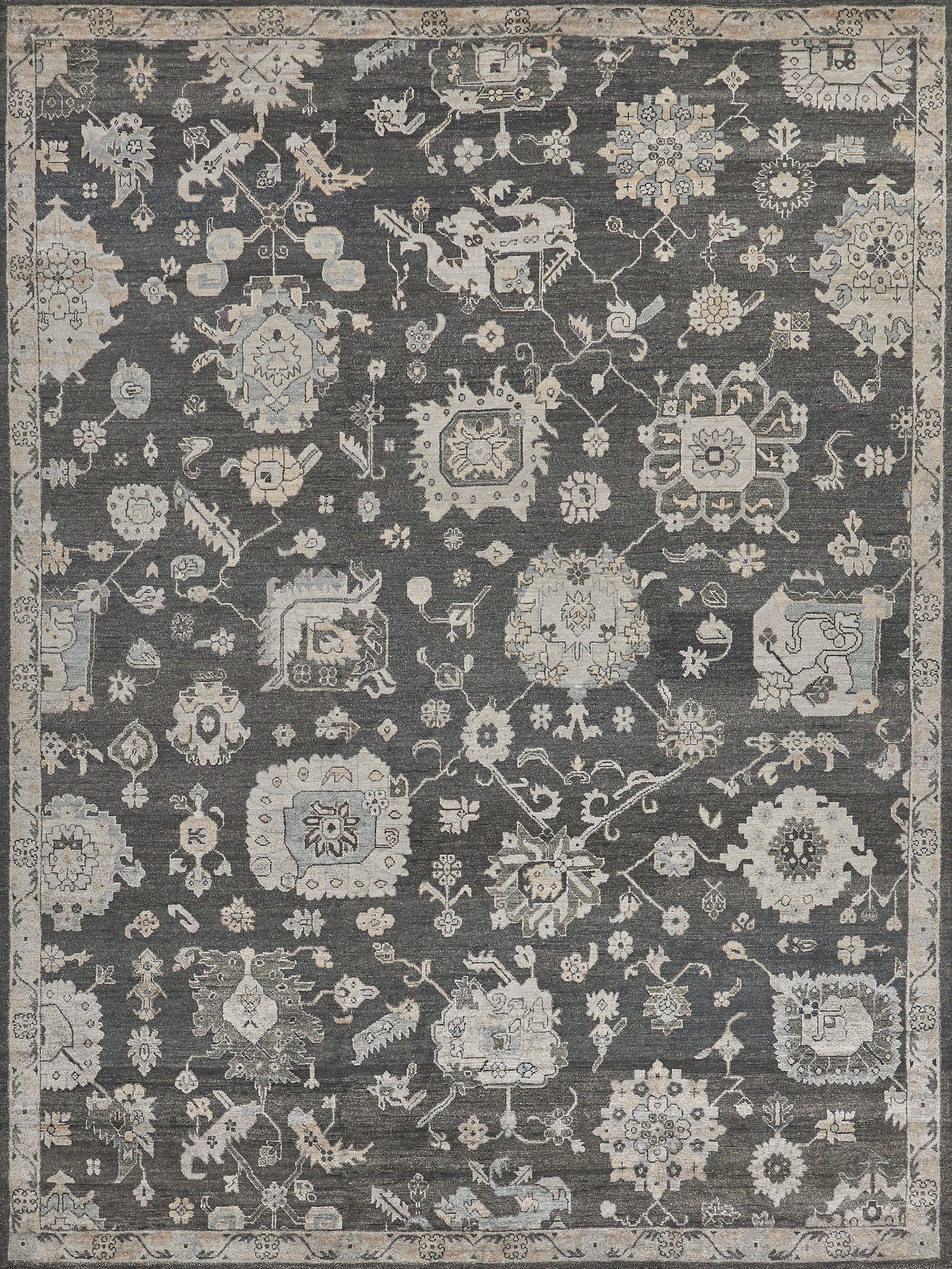 Dark gray oriental rug with ivory and pale blue floral medallions, scrolling vines, and a decorative border.