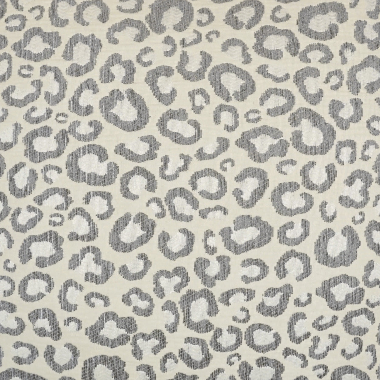 Grey leopard print fabric on beige background; soft woven textile.