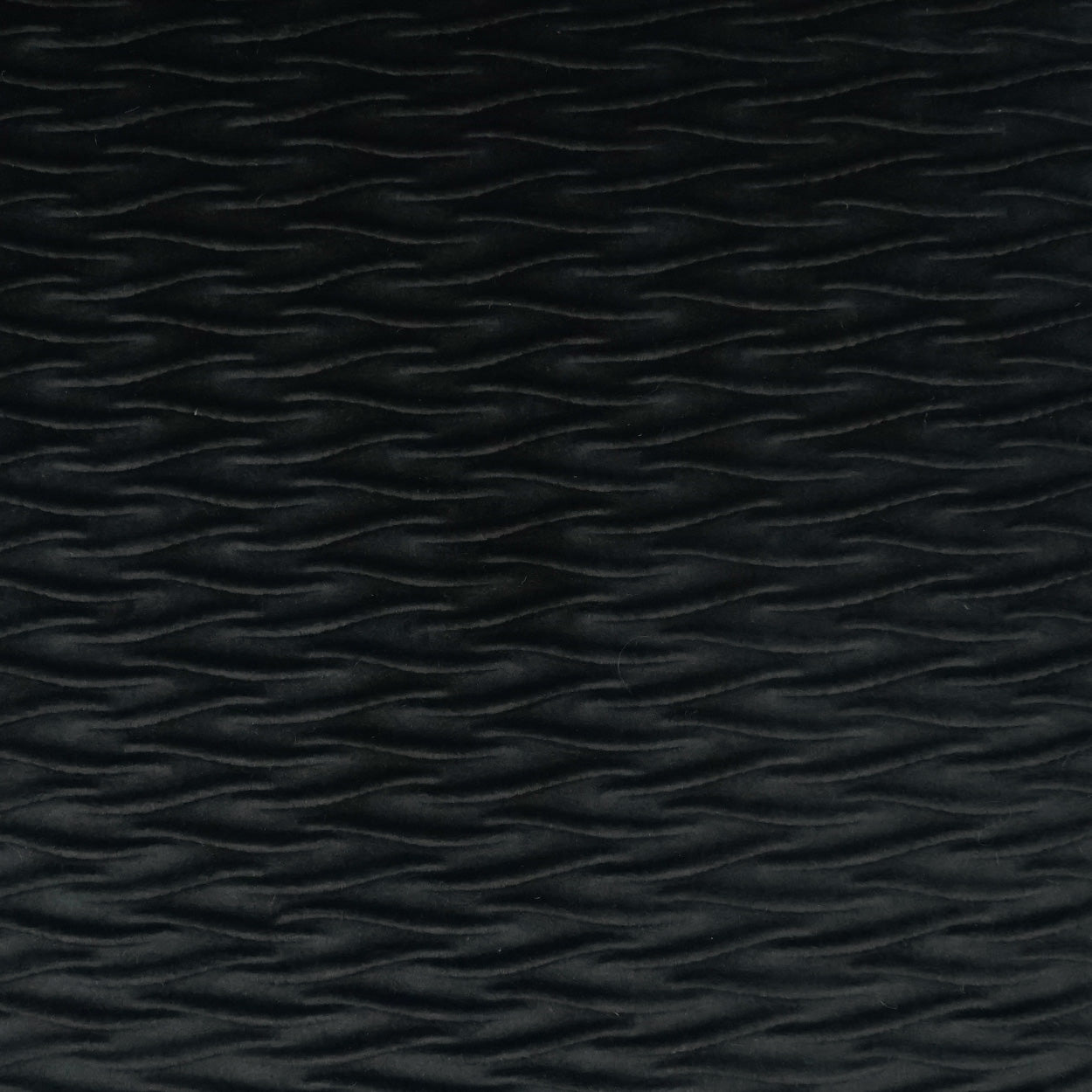 Black textured fabric with subtle horizontal wavy ridges, embossed pattern.