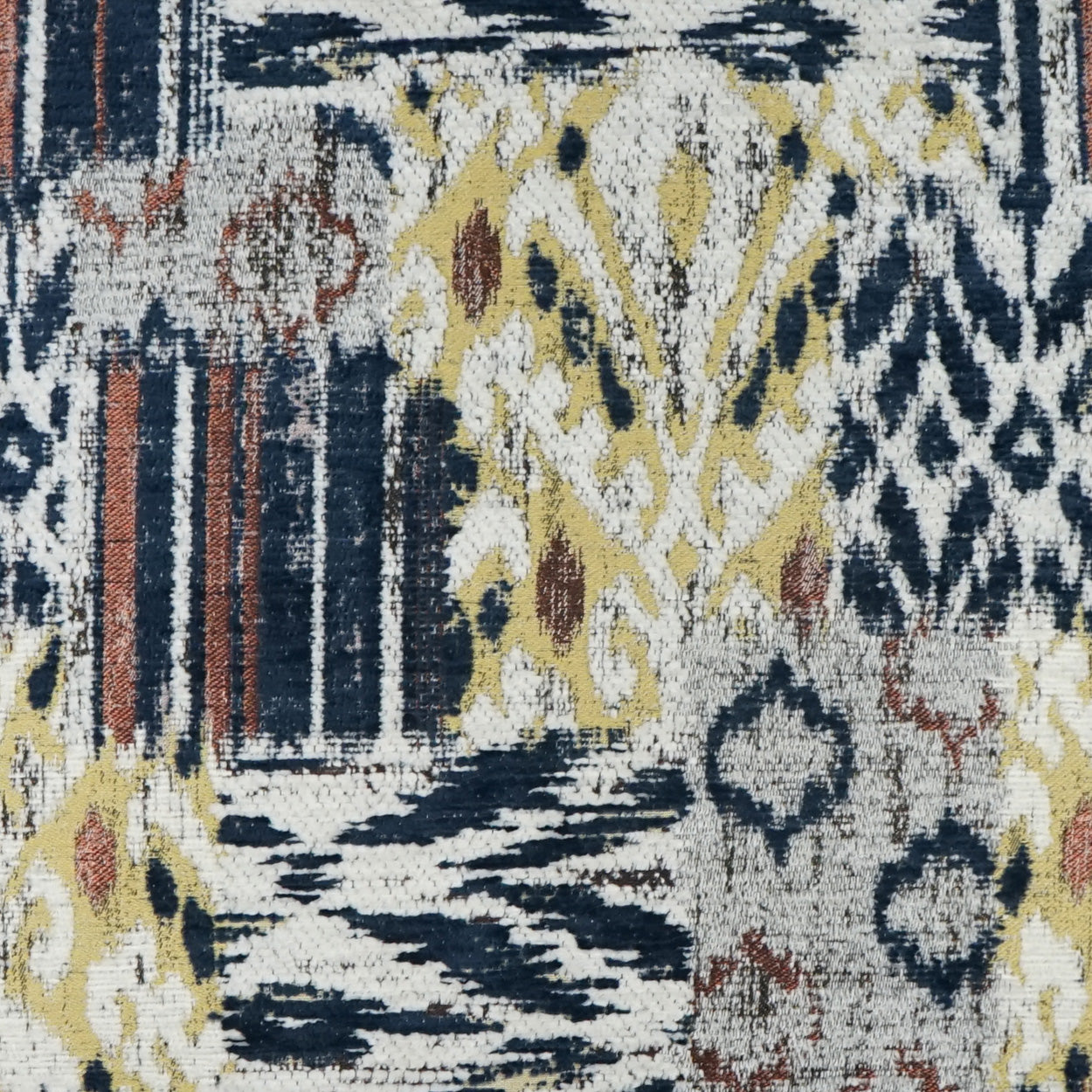 Woven textile with ikat-inspired geometric motif in navy, ivory, mustard yellow and rust; rug or upholstery fabric.