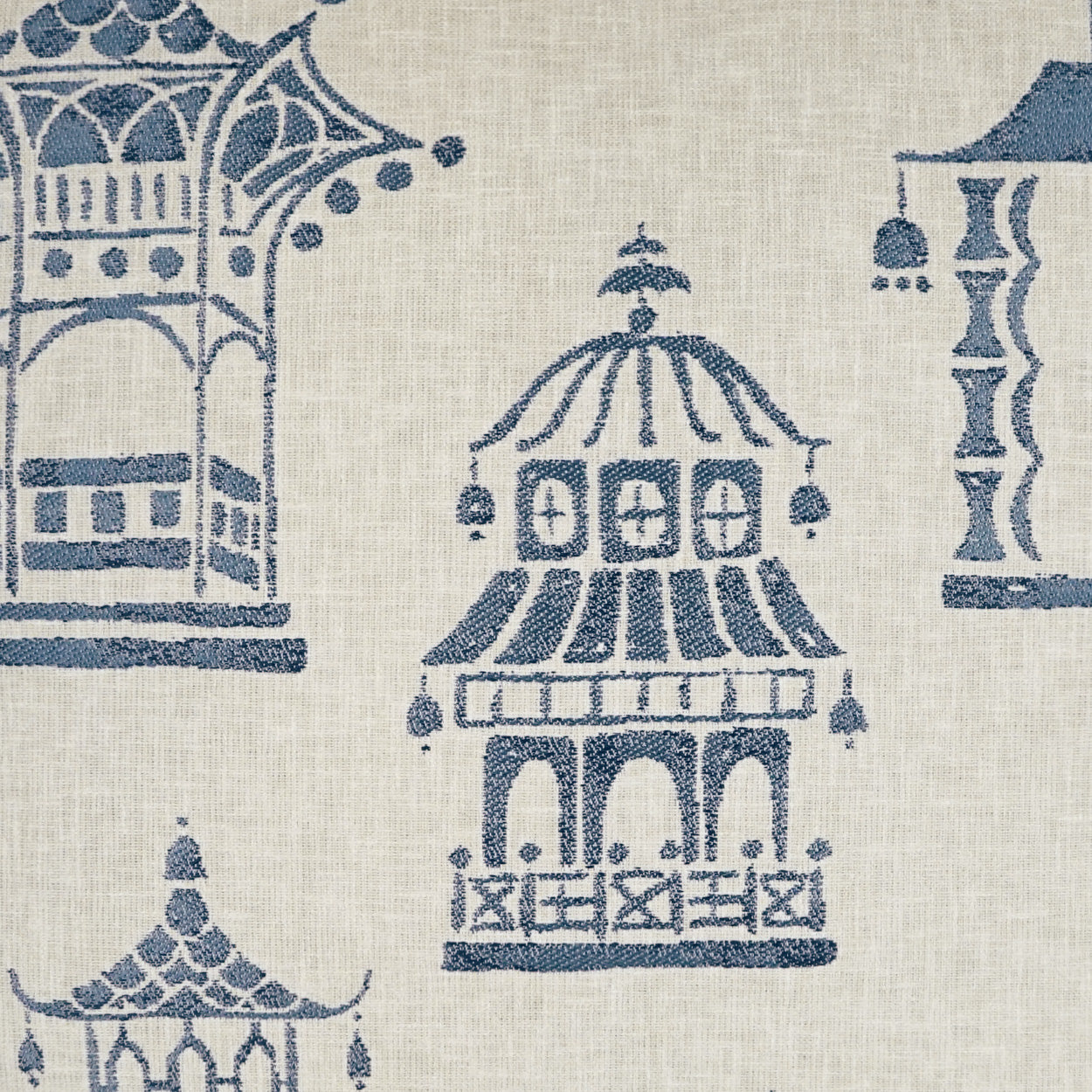 Beige linen-like fabric with blue temple and pagoda motifs; decorative textile for upholstery or curtains.