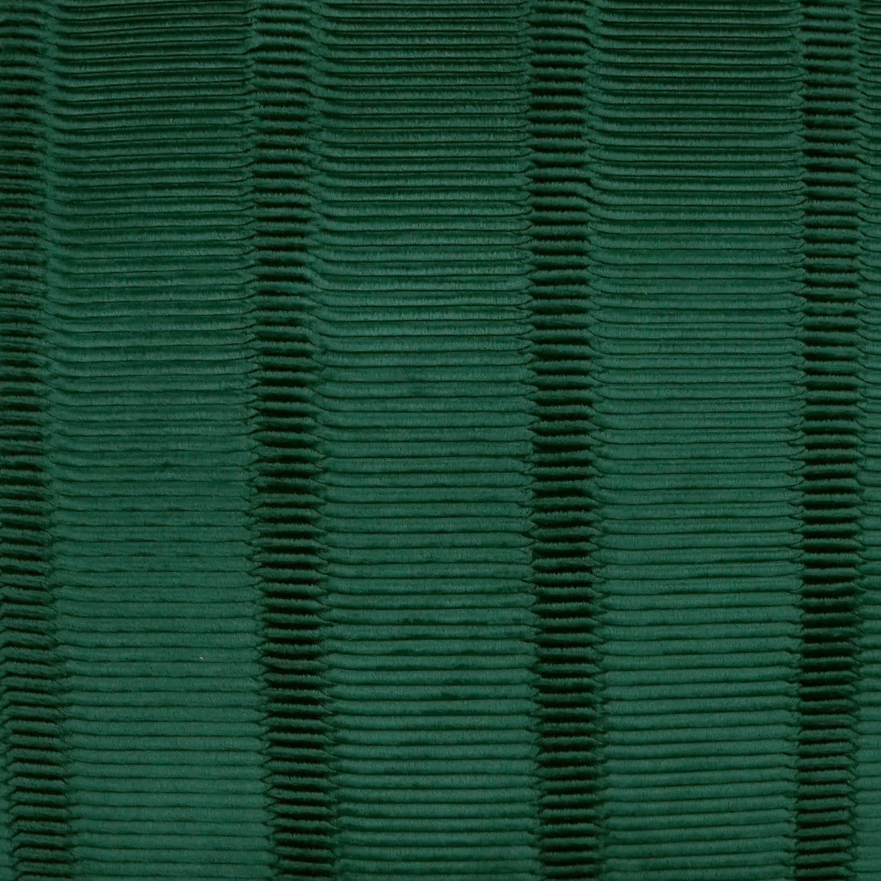 Emerald green ribbed fabric close-up with horizontal ridges; textured knit/woven material for apparel or upholstery.