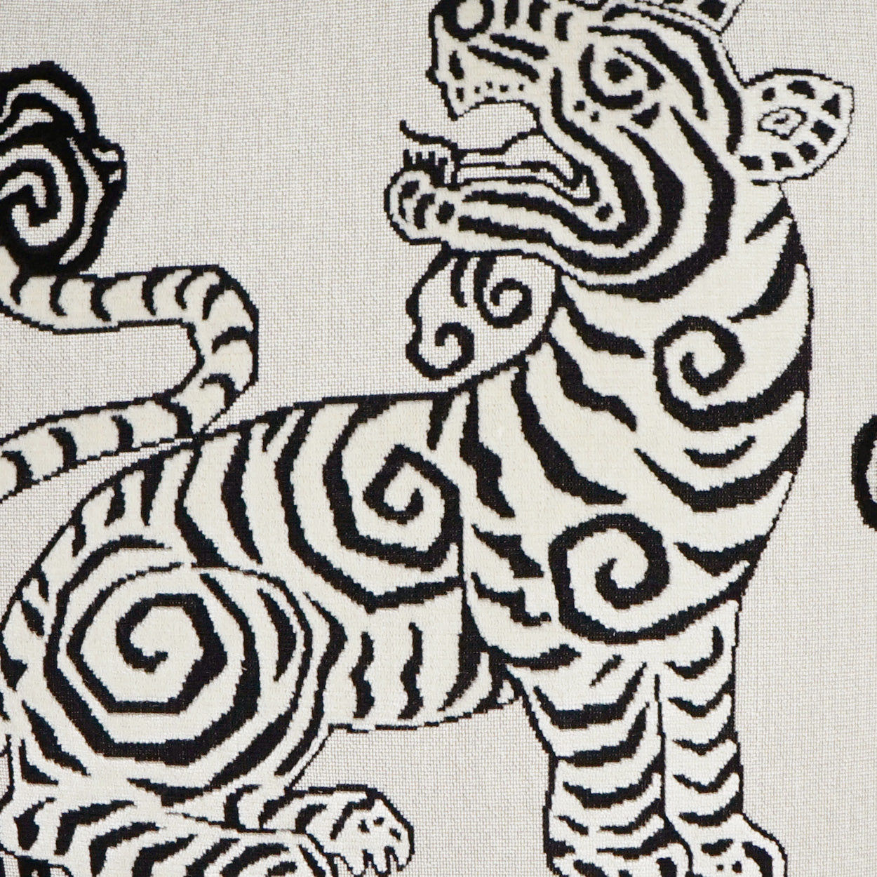 White fabric with bold black zebra print featuring swirling, curved stripes and stylized zebra figures.