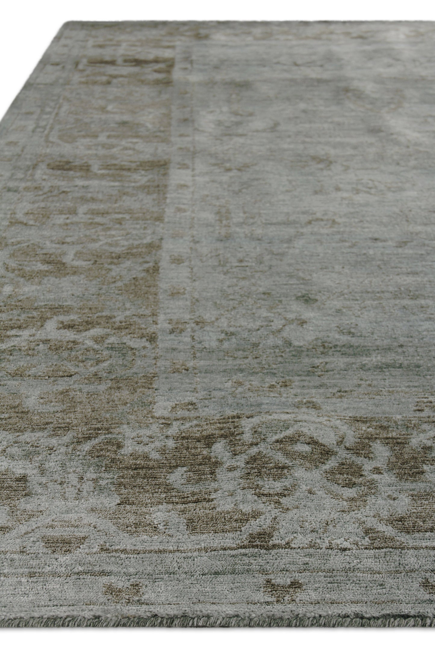 Rectangular blue-gray distressed rug with muted tan oriental motifs & fringed ends, suitable for living room.