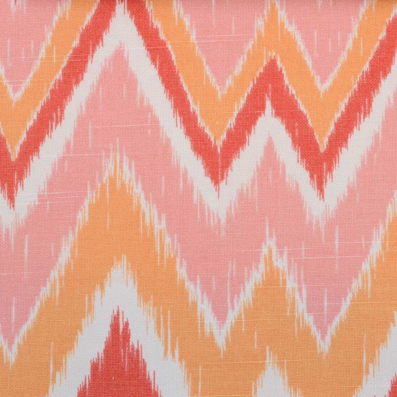 Ikat-inspired zigzag chevron pattern in pink with peach, coral and white accents on textile fabric.