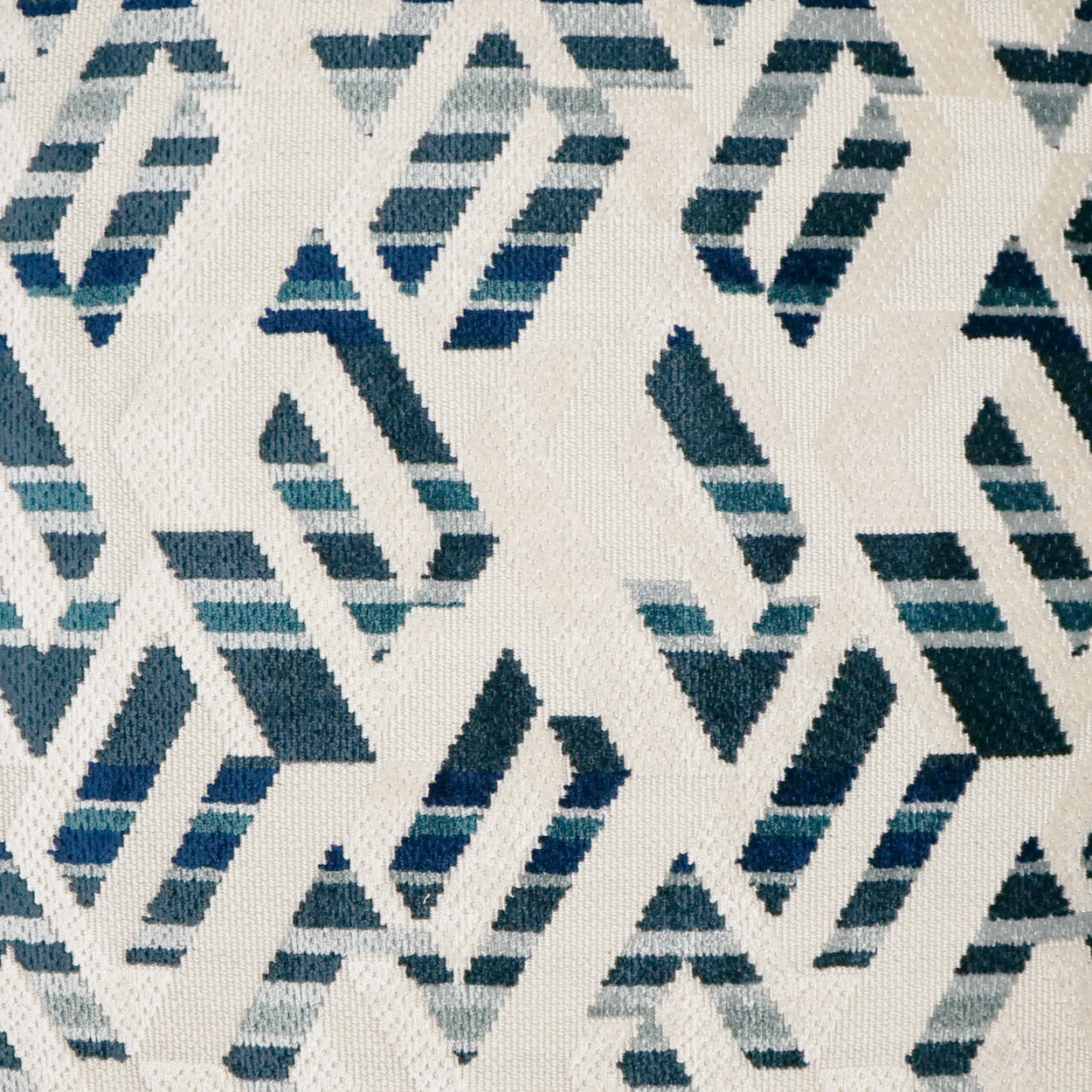 Cream fabric with teal and navy geometric zigzag diamond motifs.