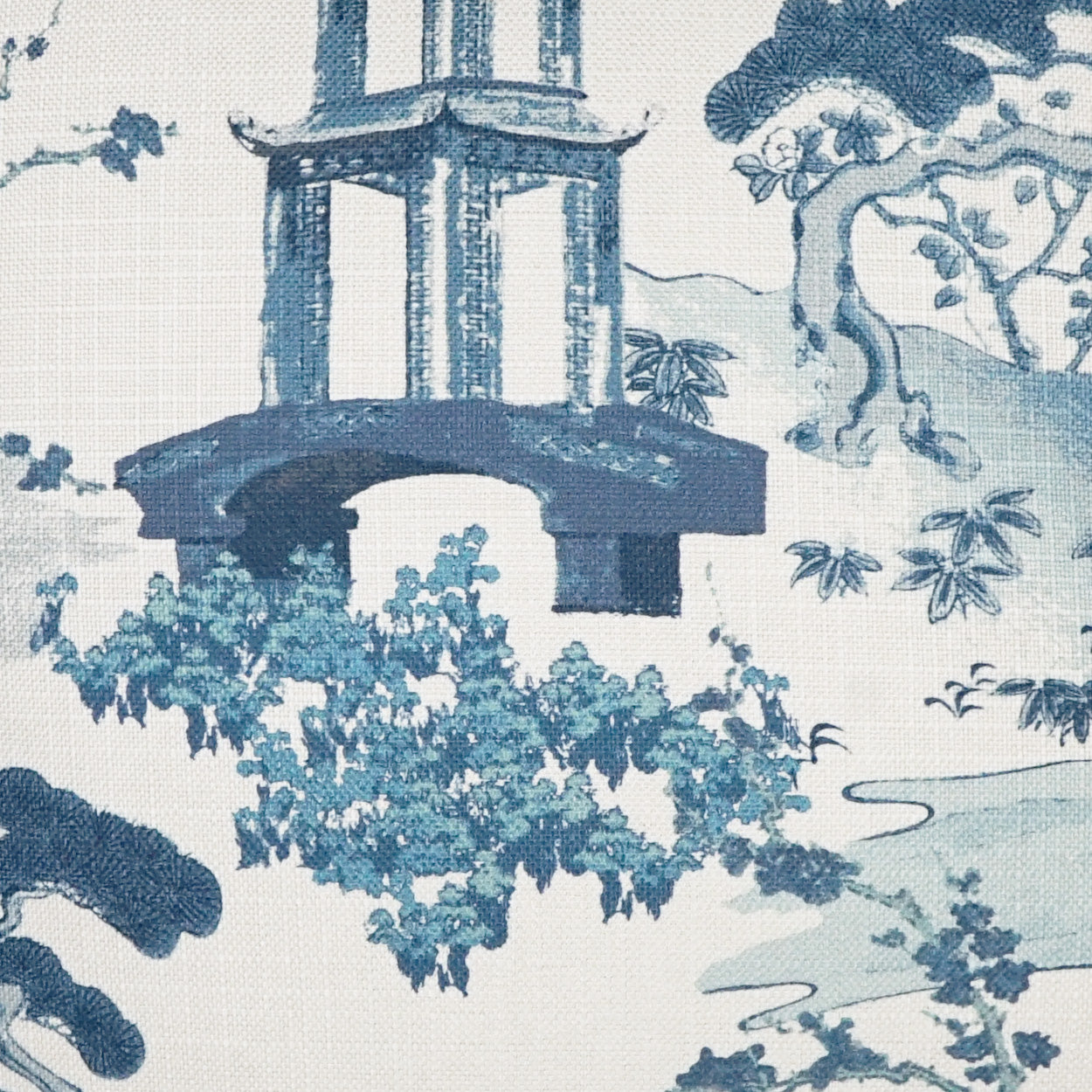 Blue & white toile fabric featuring a pavilion, trees, & a river scene; woven textile for upholstery or drapery.