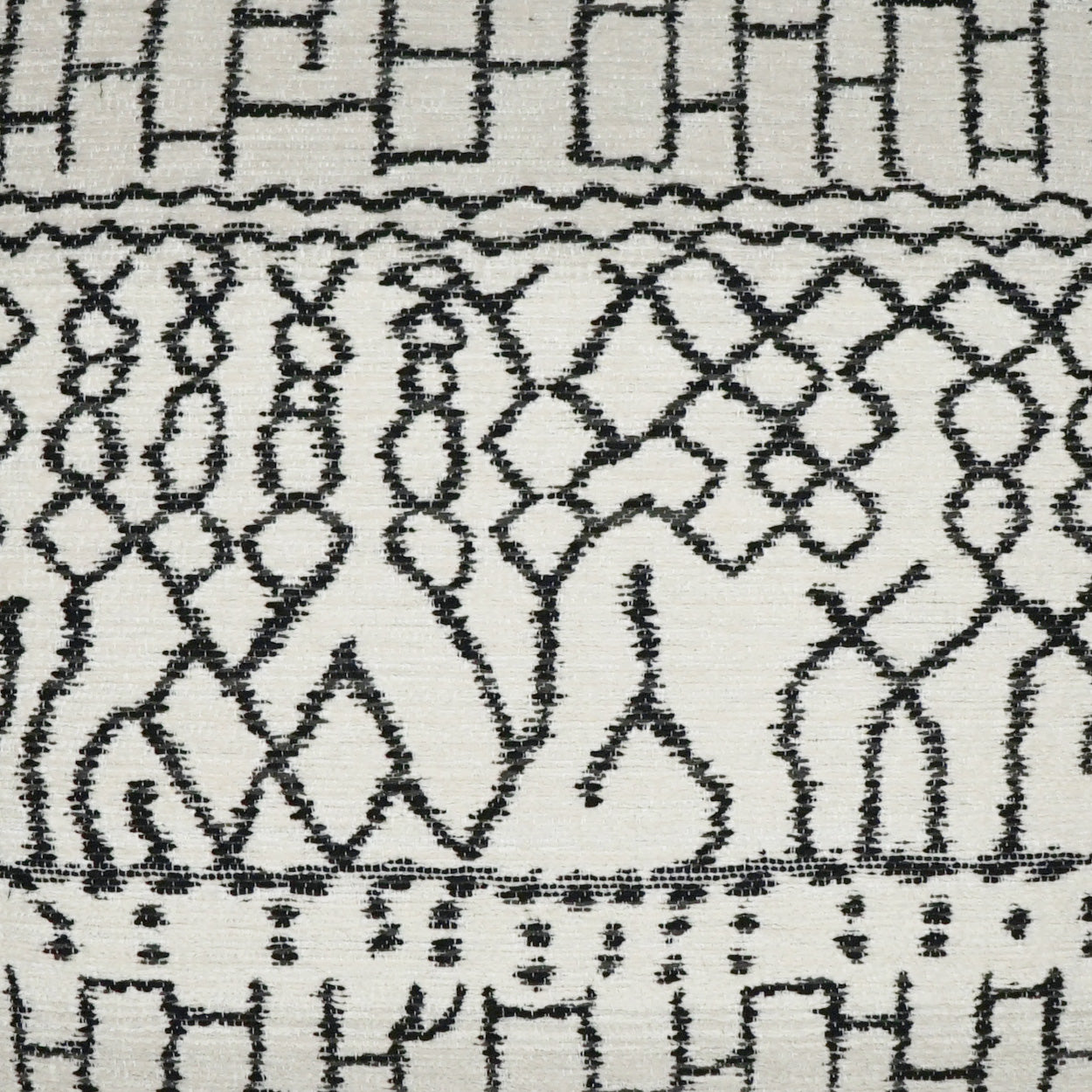 White fabric with black geometric tribal pattern featuring diamond lattice and arch motifs; textured weave.