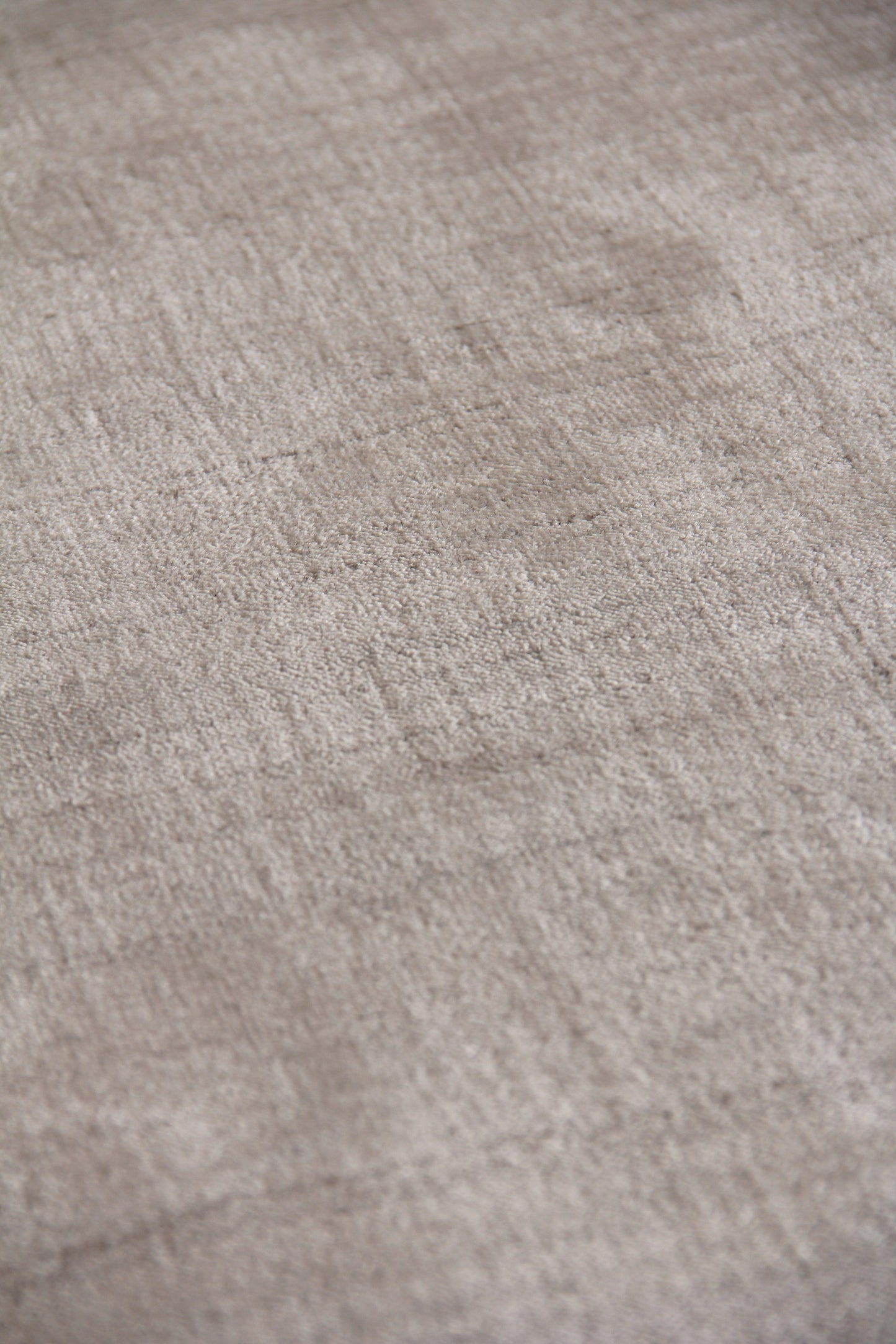 Beige plush rug close-up showing soft, textured pile in neutral tan tones.