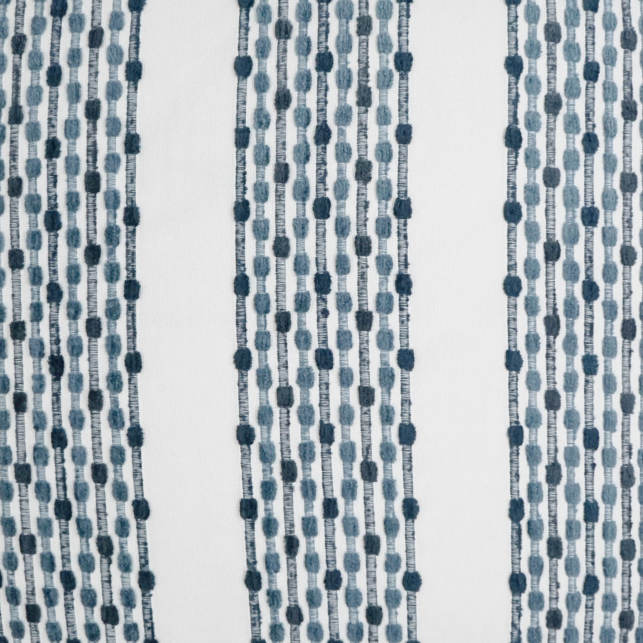 Blue beaded curtain fabric with vertical strings of round beads; decorative textile pattern.