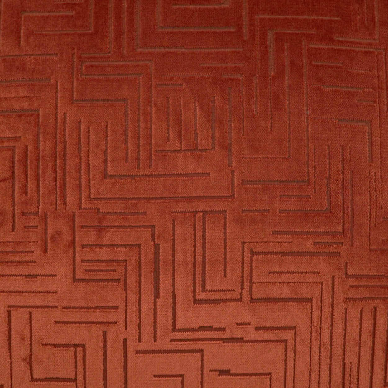 Terracotta fabric with embossed geometric maze pattern; soft suede-like upholstery texture for furniture use.