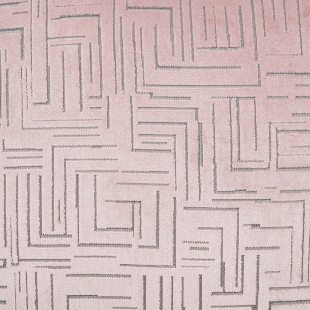 Pink fabric with dark grey maze-like geometric stitching, a modern decorative textile pattern.