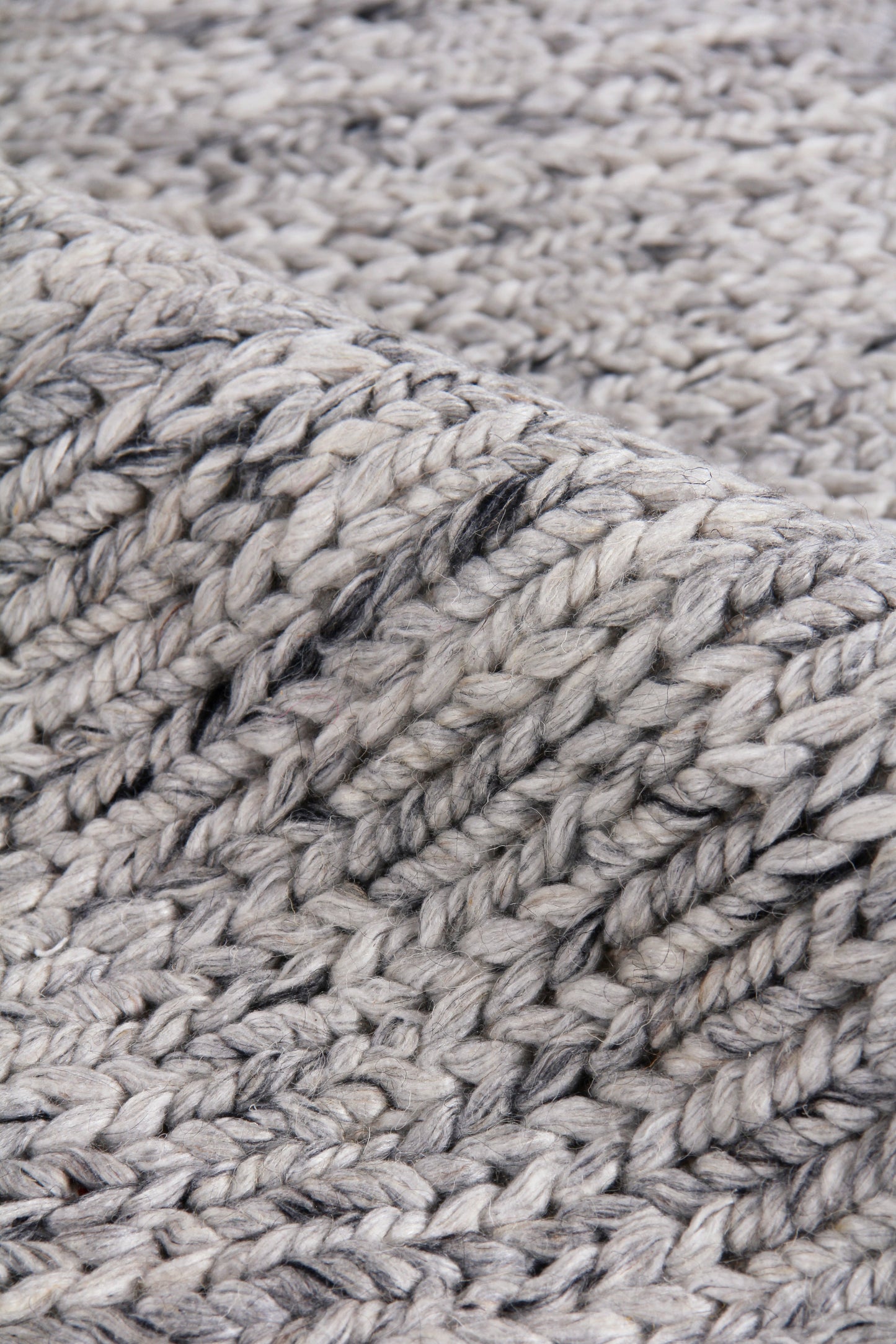 Close-up of chunky heather gray woven rug texture with thick twisted fibers; hand-woven look, 2' x 3'.