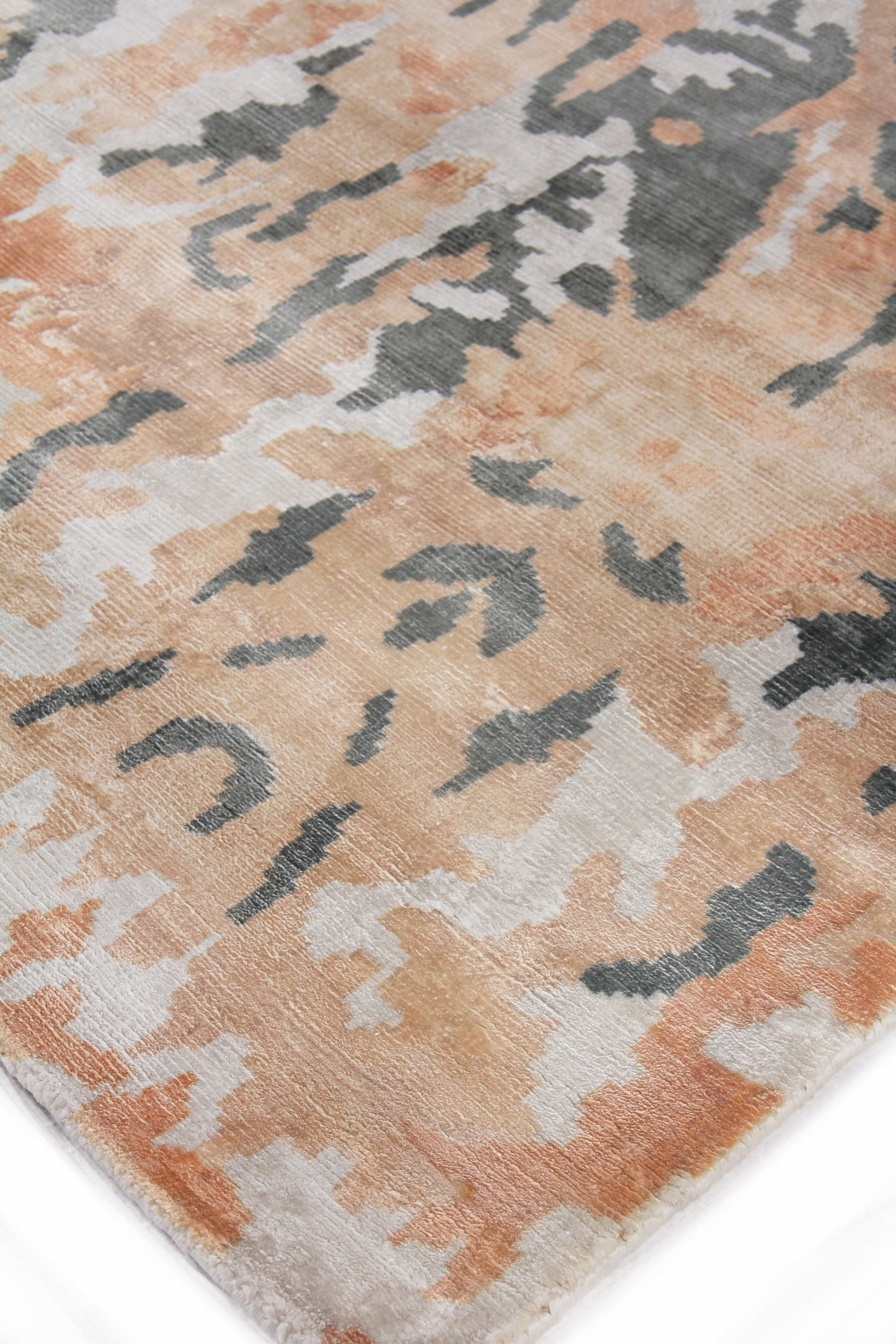 Abstract camo-style area rug in peach, cream, beige and gray with a soft plush pile.