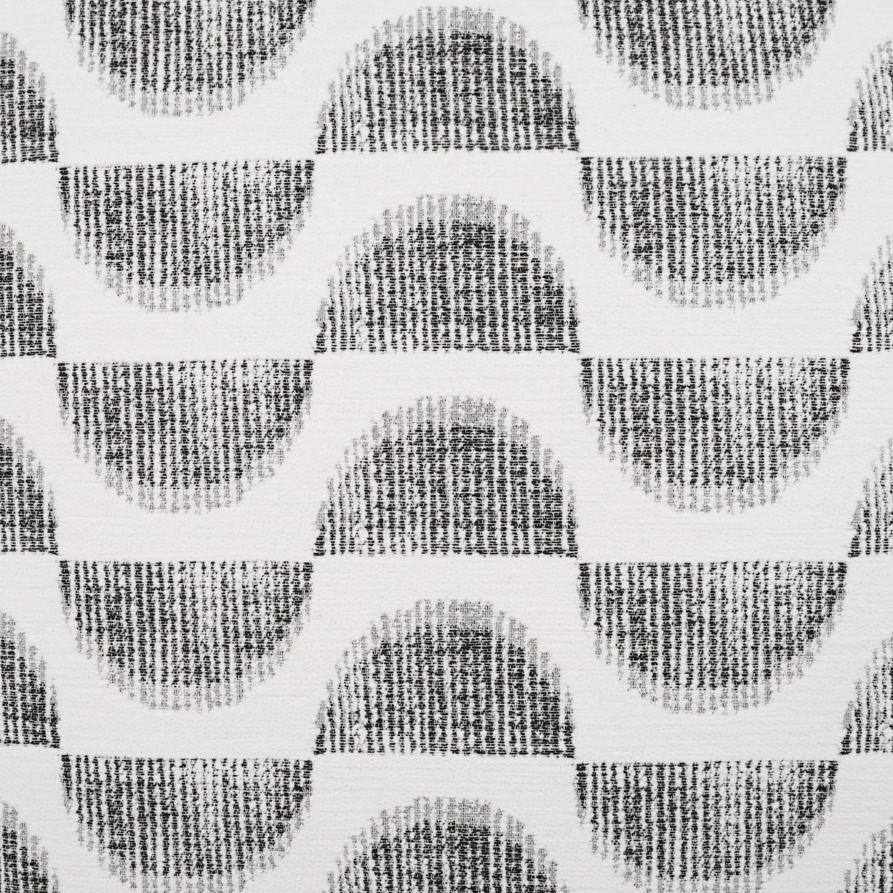 Black and white fabric with a repeating curved arc motif—dark semicircles on a light background.