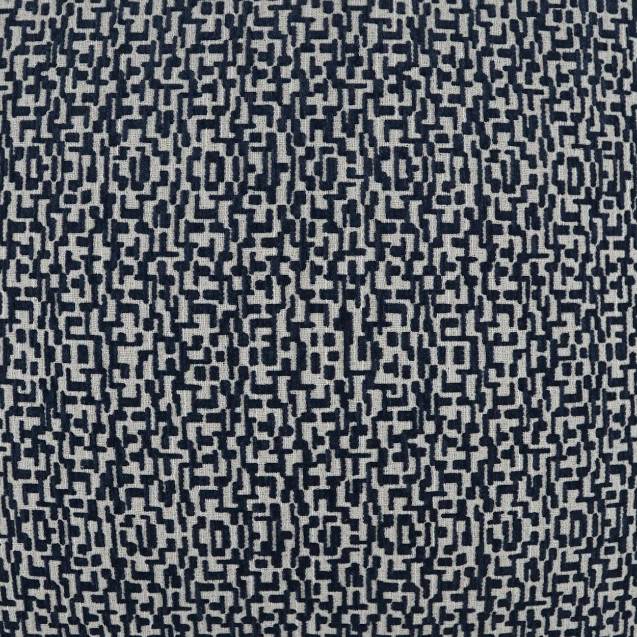 Navy and cream woven fabric with a dense geometric interlocking block lattice pattern