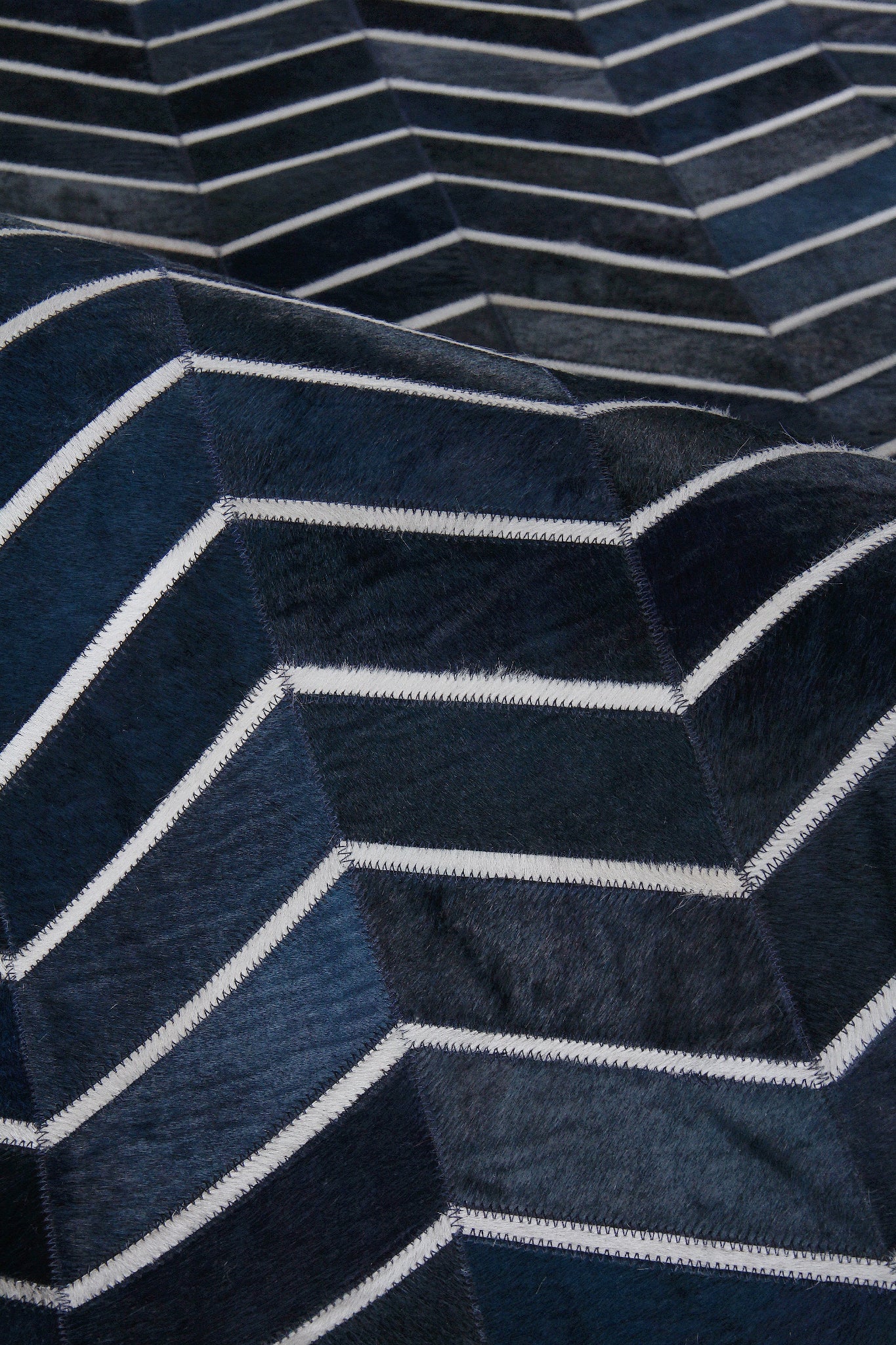 Natural hide indoor hand-stitched rug, 5' x 8'.