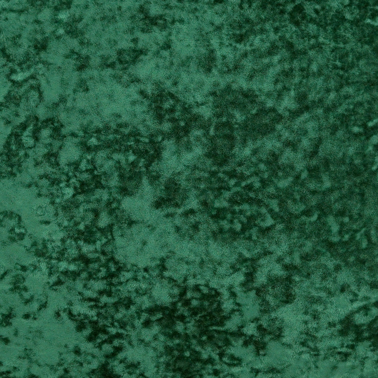 Emerald green crushed velvet fabric texture with mottled dark and light areas.
