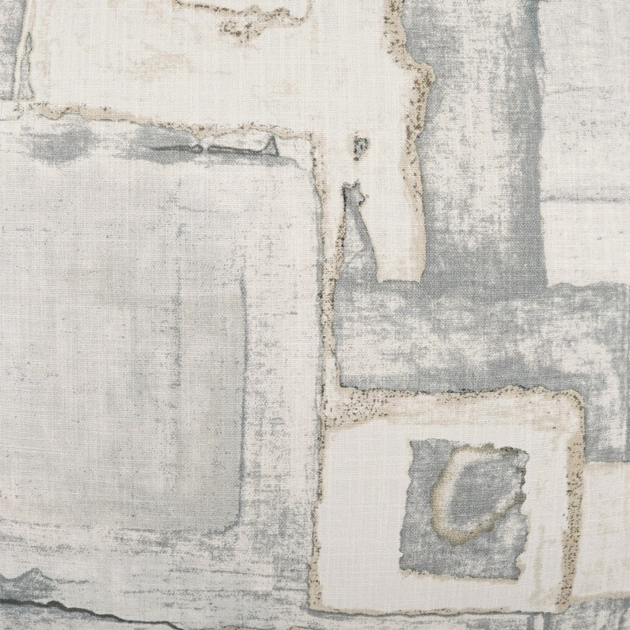 Patchwork fabric in gray and cream tones; textured woven textile with frayed edges.