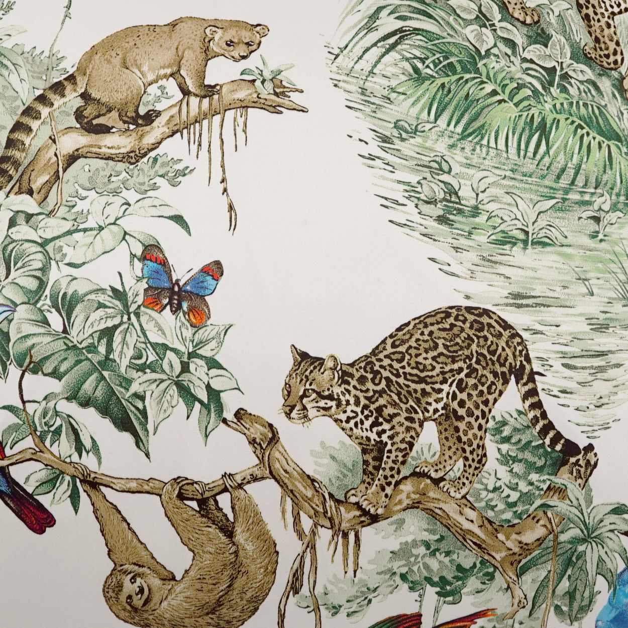 Tropical fabric print with leopard on a branch, a lounging sloth, lush jungle foliage, and a blue-orange butterfly.