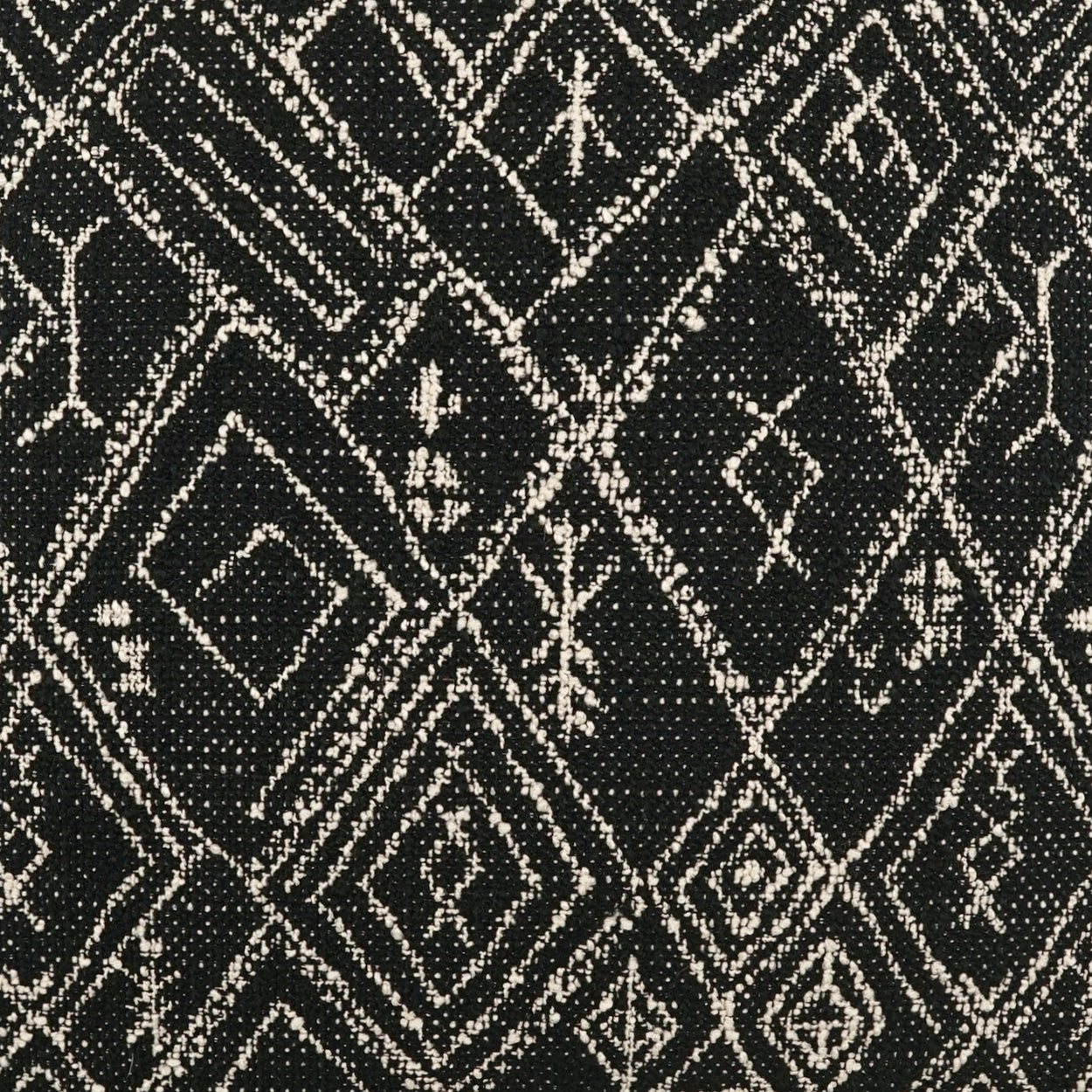 Black woven fabric with cream diamond geometric pattern; lattice/tribal motif, textured textile.