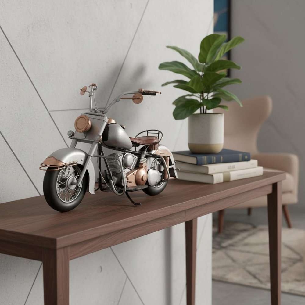 Vintage motorcycle model in metallic silver and tan leather on a wooden console table, beside a potted plant and books.