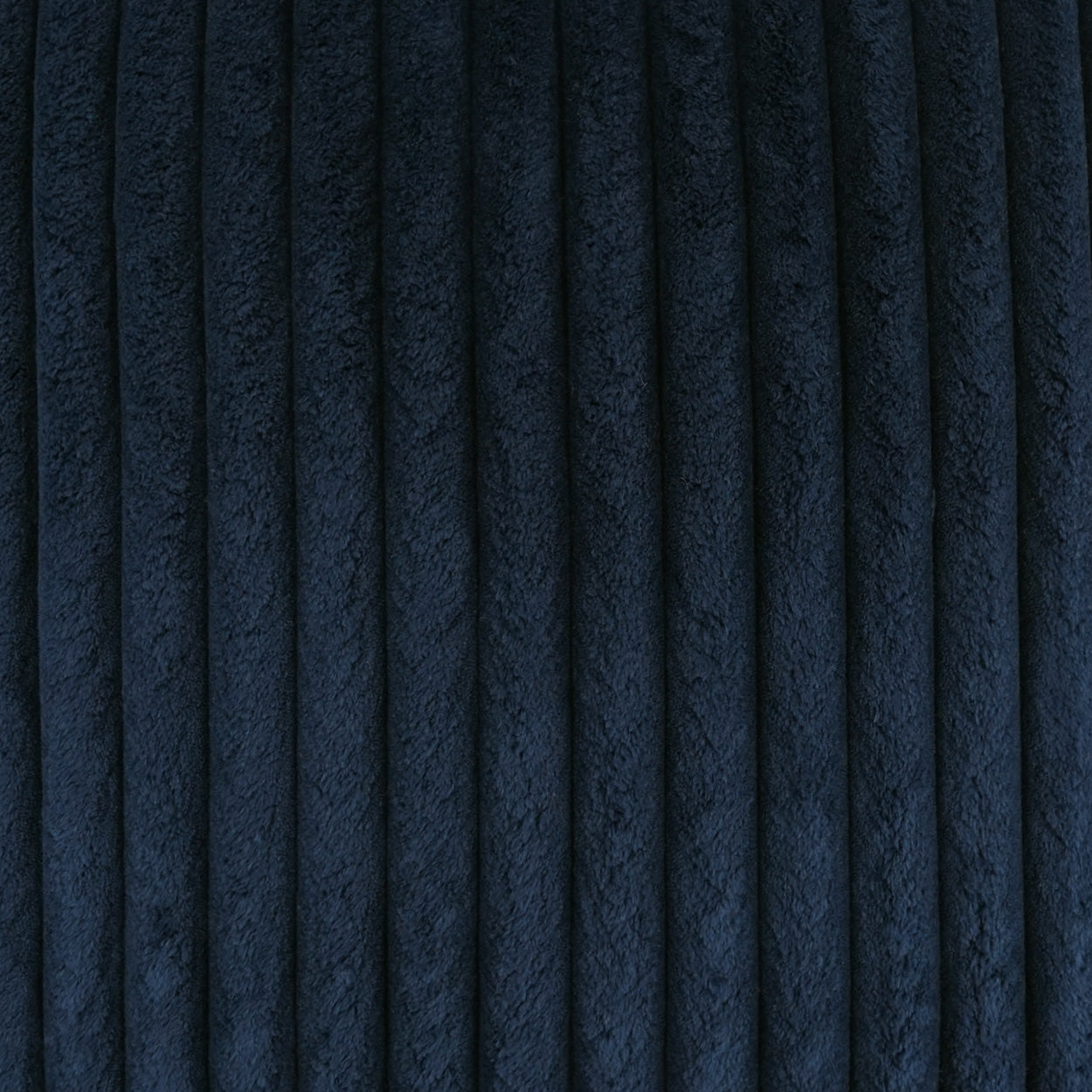 Navy blue corduroy fabric with vertical wales; soft, textured textile for clothing or upholstery.