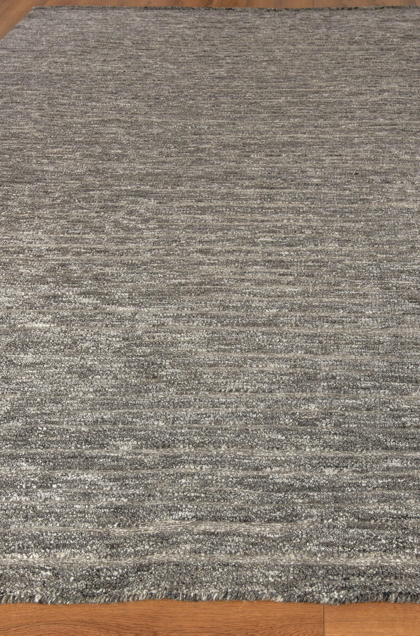 Gray marled hand-knotted area rug with subtle striped texture on hardwood floor, 6' x 9'.