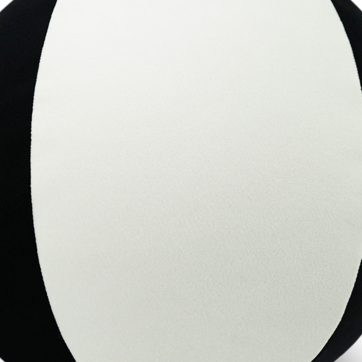 Cream fabric close-up with smooth, subtle texture against a black background.