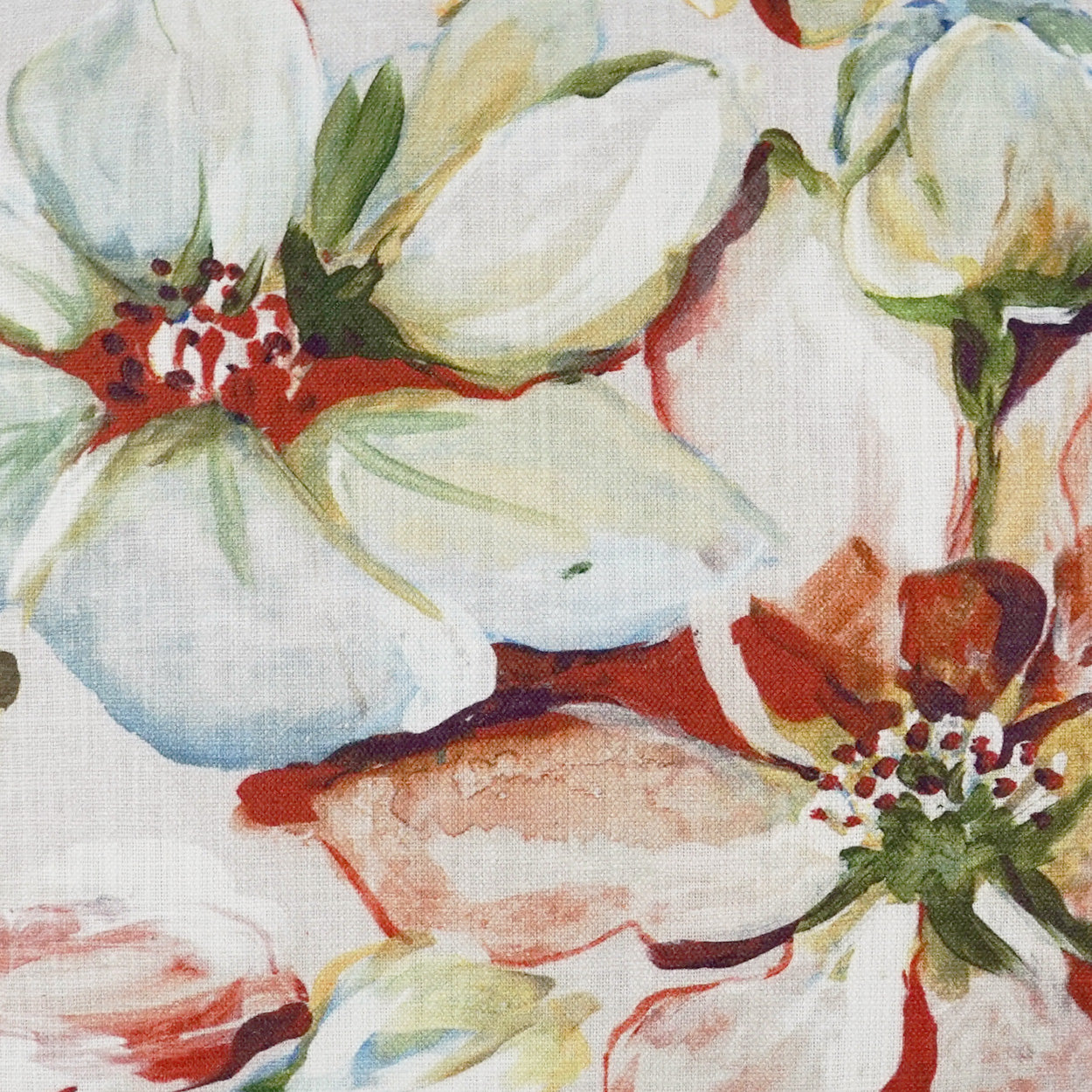Pillow with watercolor floral pattern featuring large white flowers, green leaves, and red accents; soft painterly print.