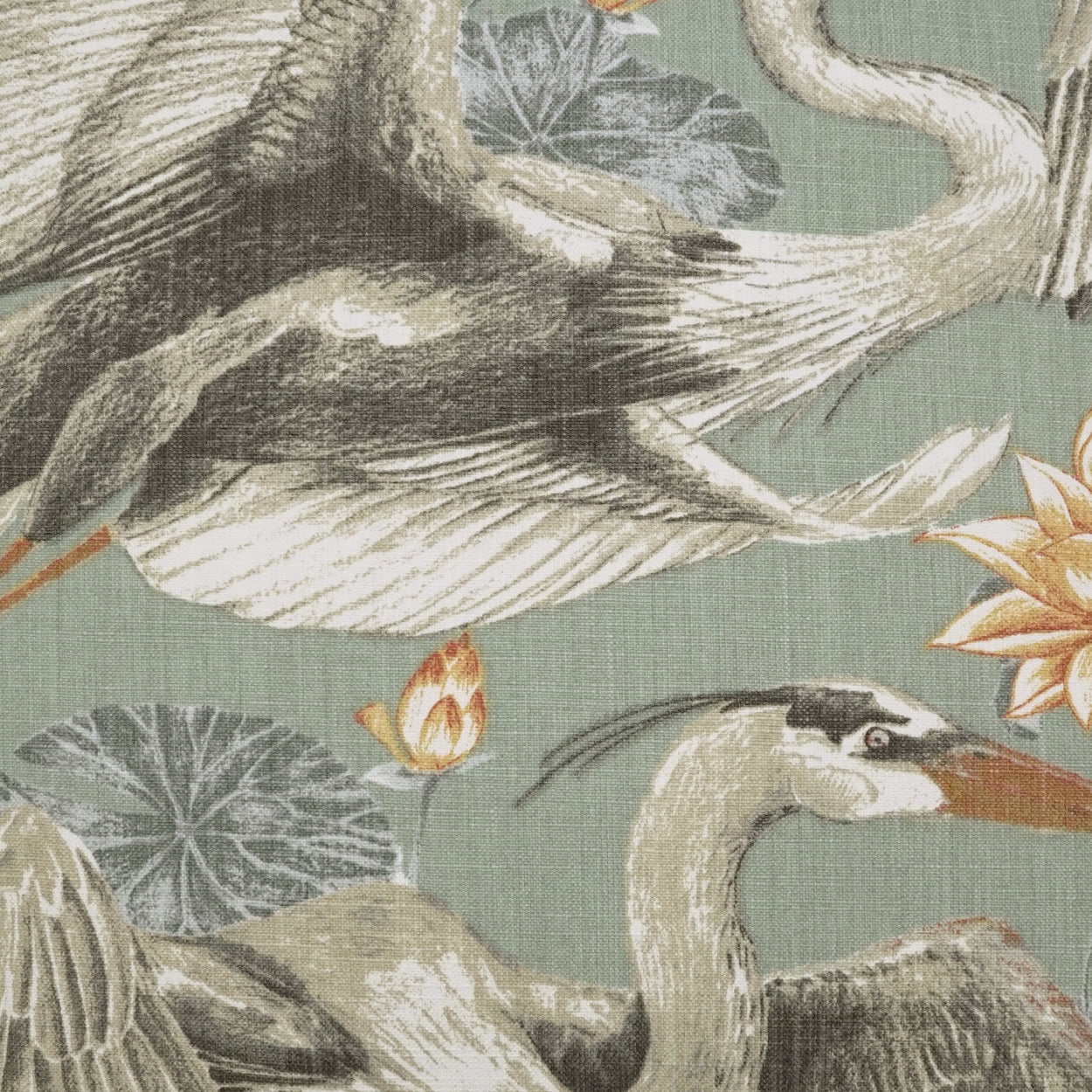 Fabric print of cranes and lotus leaves on a muted sage-green background; botanical wildlife textile pattern.