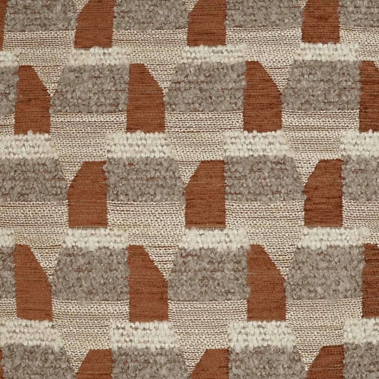 Textured rust boucle pillow with a geometric stepped-arch pattern.
