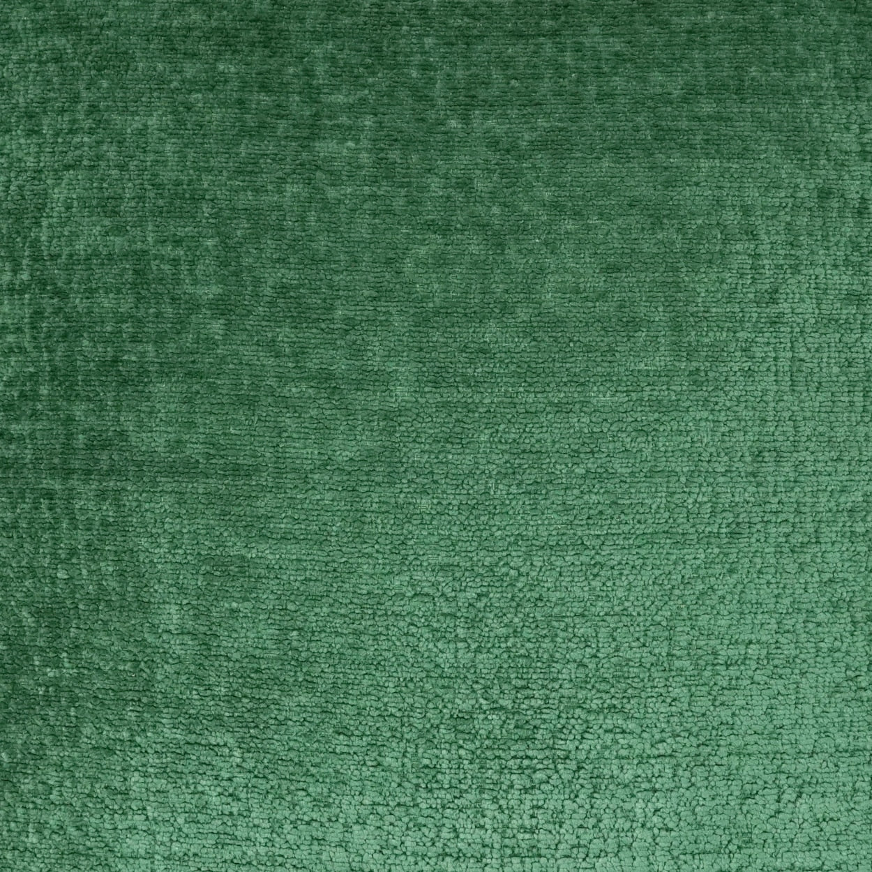 Emerald green velvet fabric close-up with soft pile and subtle sheen