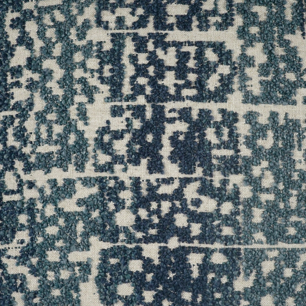 Teal and cream woven fabric with a distressed pixelated geometric pattern, suitable for upholstery or rugs.