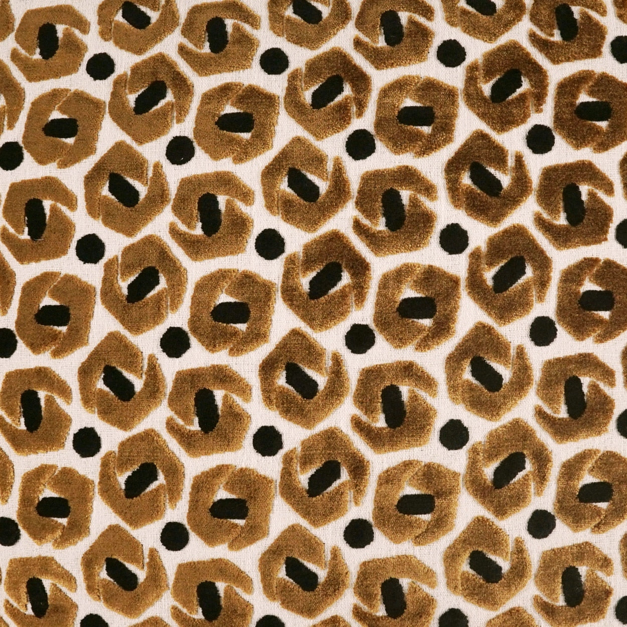 Tan fabric swatch centered on leopard print border; textile sample for fashion accessories.